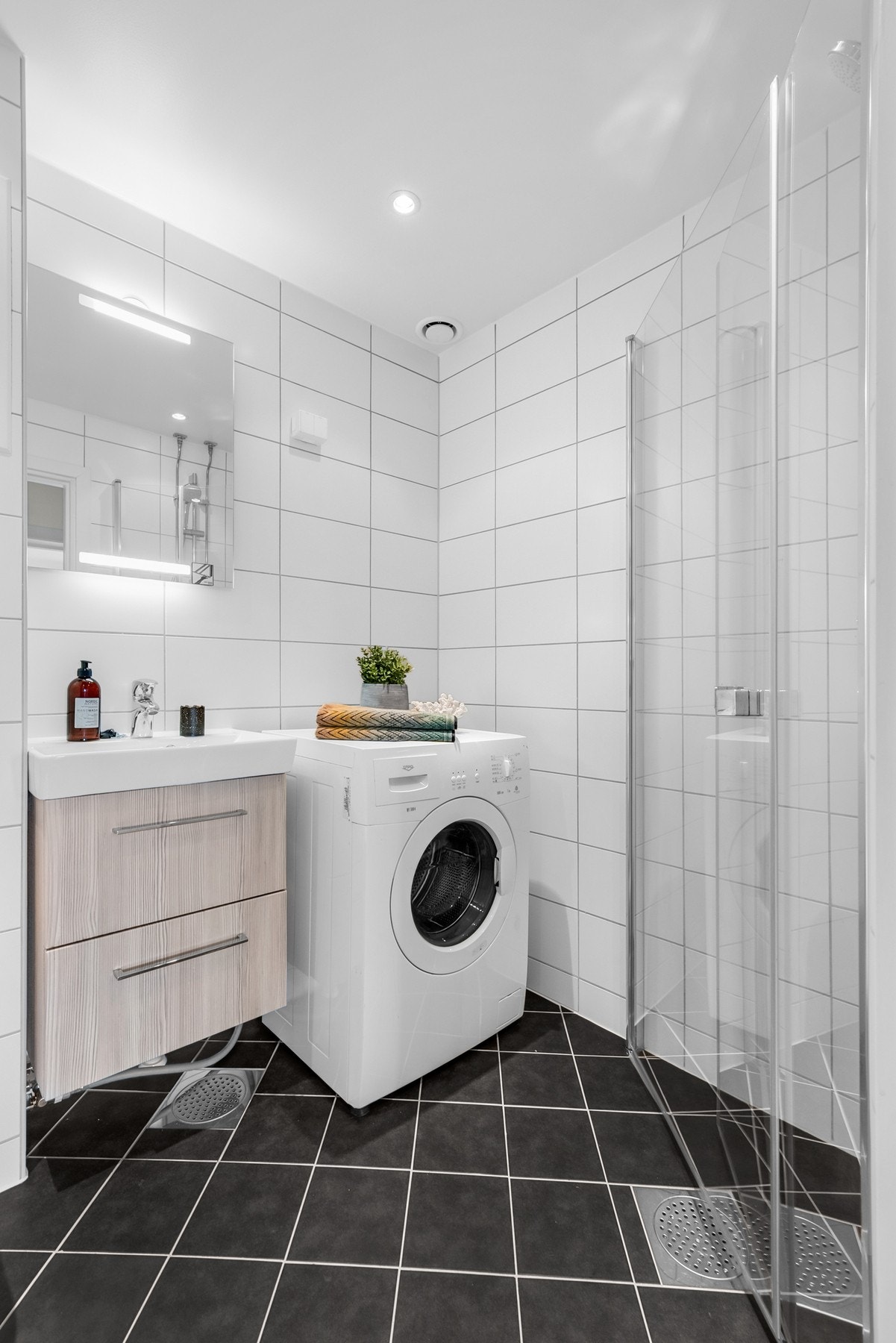 Eget dusjhjørne med svingbare glassdører og termostatstyrt blandebatteri. Videre er badet utstyrt med opplegg for vaskemaskin. Vaskemaskinen medfølger i handelen. Galleribilde