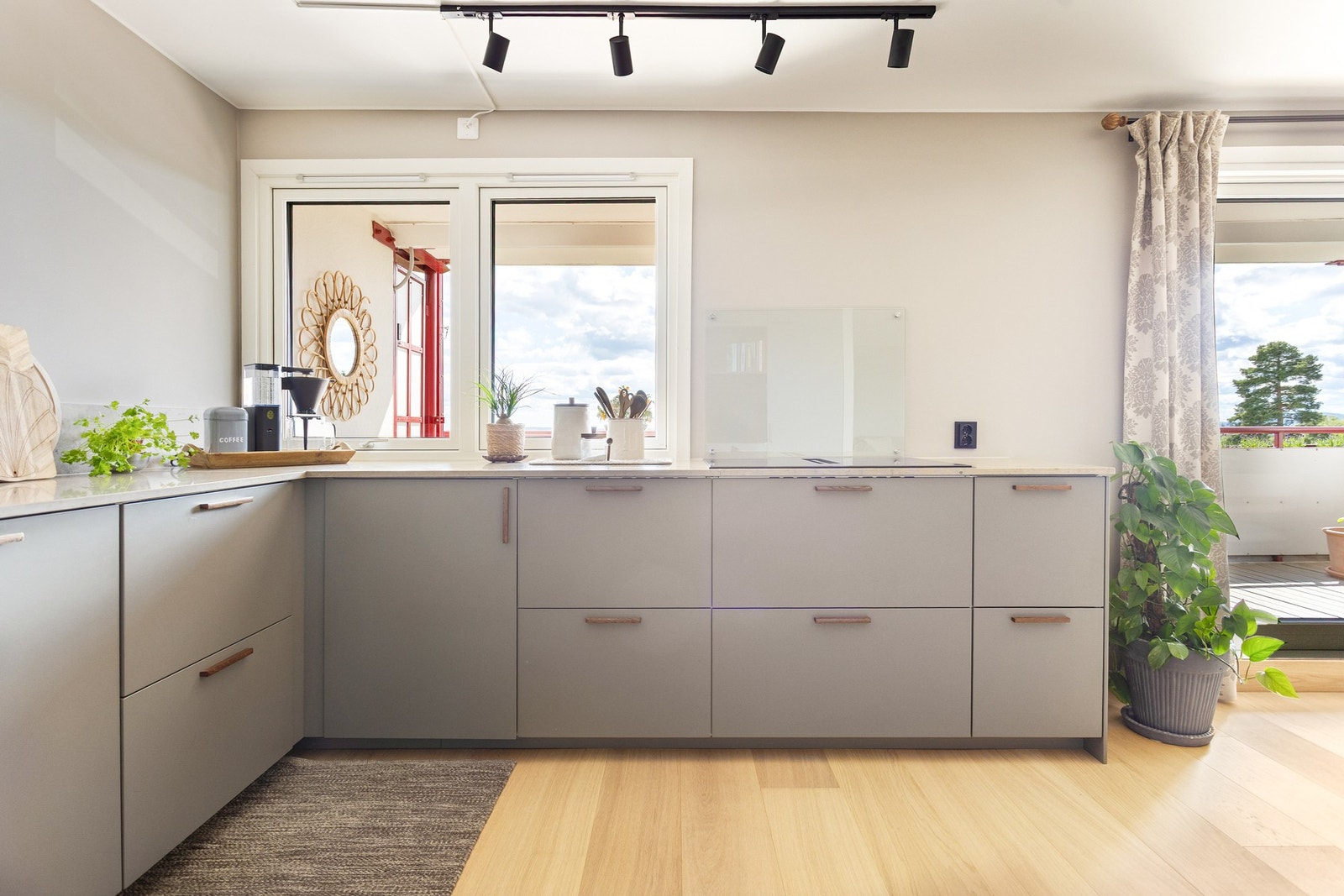 Moderne kjøkkeninnredning fra 2023 med slette fronter og benkeplater av stein med underlimt oppvaskkum. Galleribilde