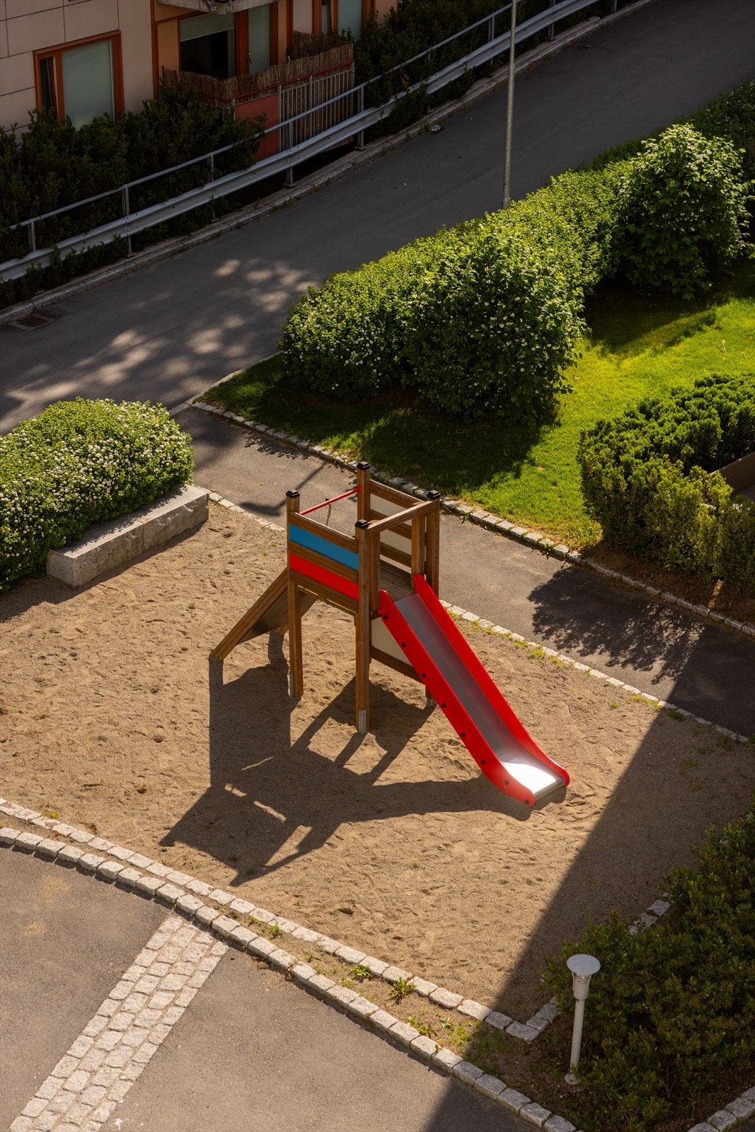 Utsikt fra balkongen over fellesarealer og lekeplassen Galleribilde