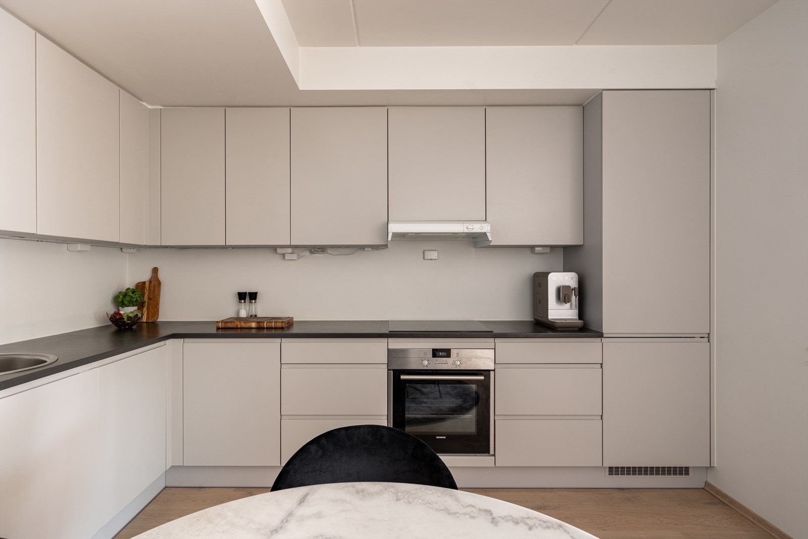 Kjøkkenet er utstyrt med integrerte hvitevarer; induksjonstopp, ventilator, stekeovn, oppvaskmaskin og kjøl/frys Galleribilde