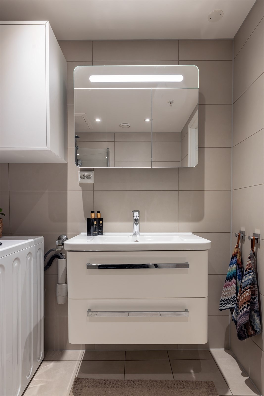 Servant med skuffer i innredning under, samt speilskap med belysning over Galleribilde