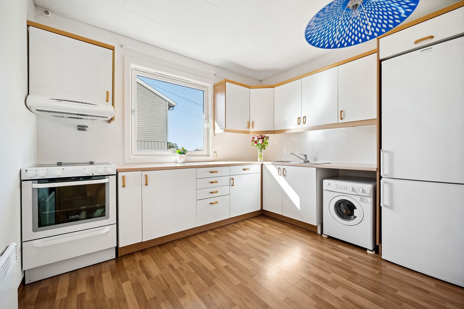 Separat kjøkken med plass til spisebord. Ny kjøkkenvifte over stekeovn, ovnsvakt og vaskemaskin. Galleribilde