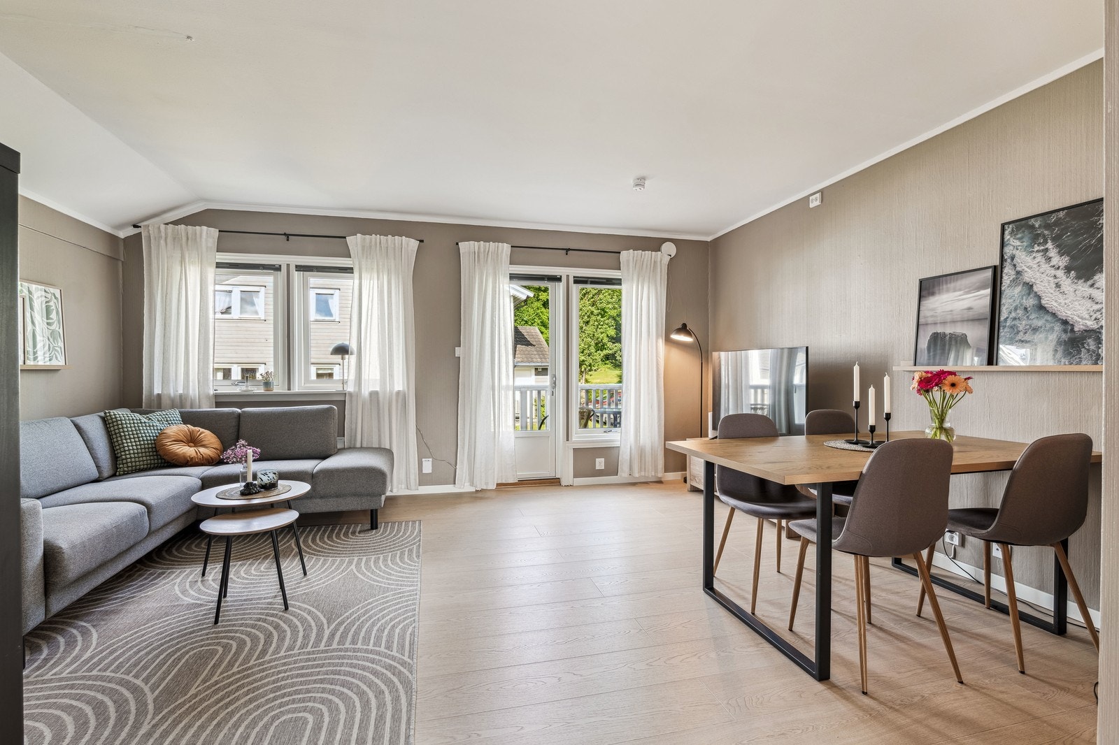 Lys og åpen stue- og spisestue i duse farger. Leiligheten leies ut møblert. Galleribilde