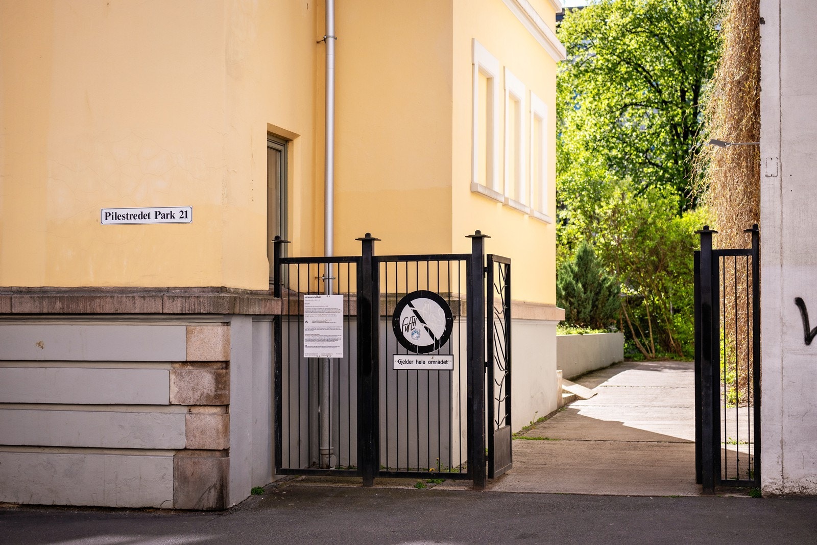 Inngang til bakgården med smijernsport inn på området. Galleribilde