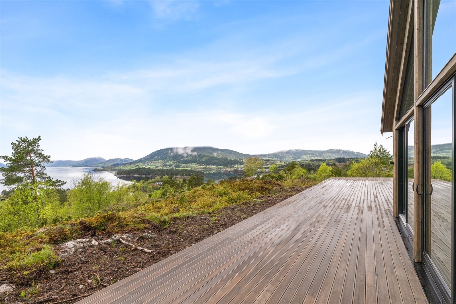 Eiendommen har en svært romslig terrasser som strekker seg rundt 3 sider av boligen Galleribilde