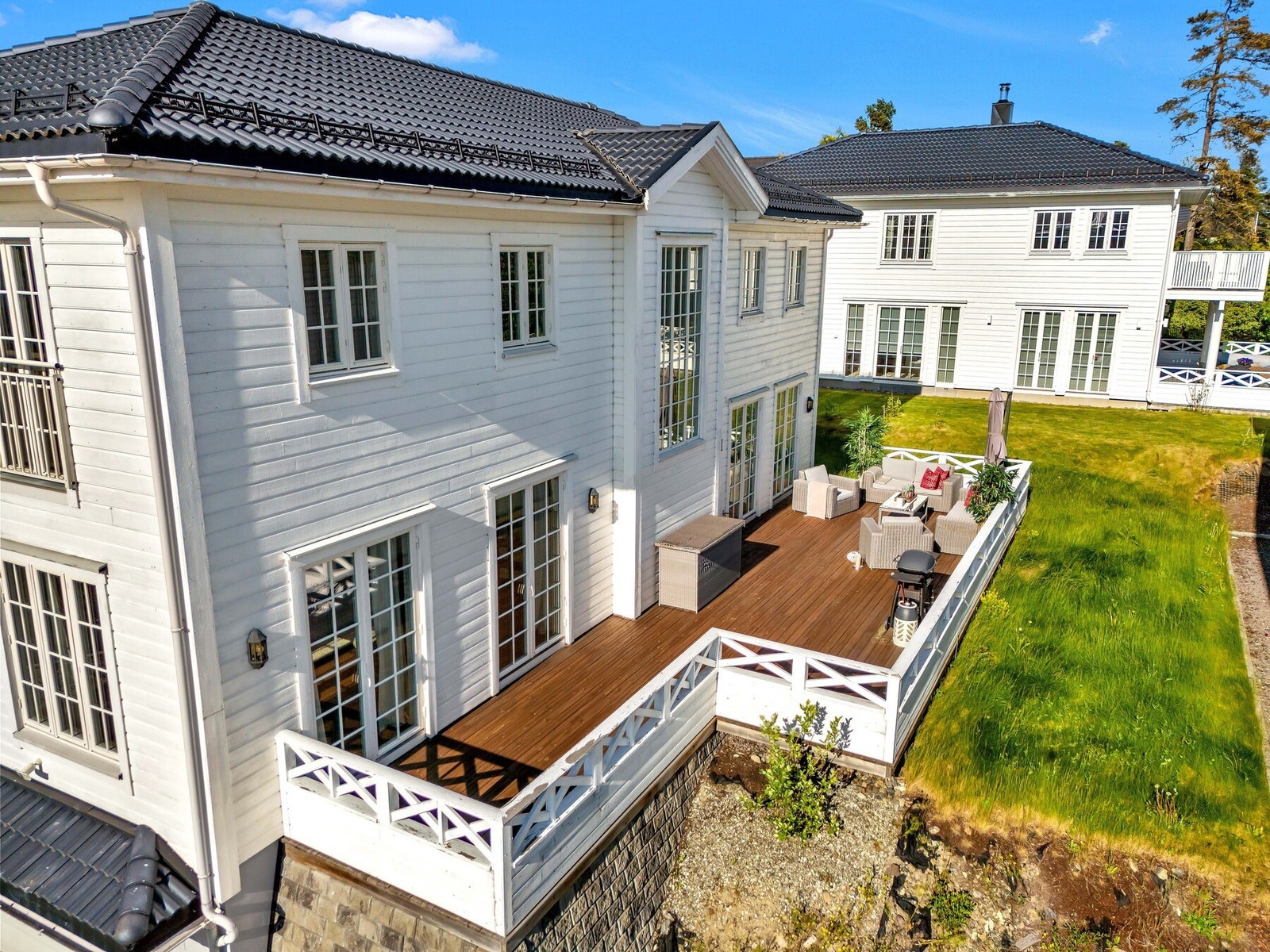 Eiendommen er pent opparbeidet med plen og beplantninger. Galleribilde