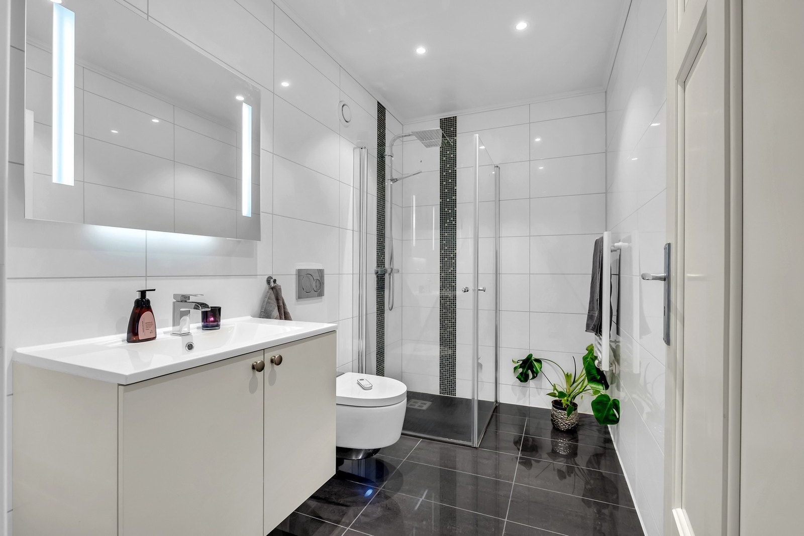 Innredningen i baderommene har fronter i kremhvitt, og over innredningen er det speil med integrert belysning. Galleribilde