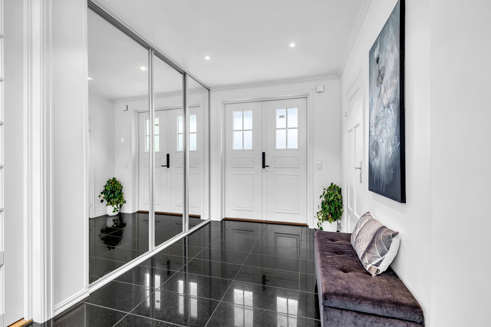 Boligen har et representativt inngangsparti med søyler til overbygg og tofløyet ytterdør med vinduer som viser vei til hallen. Galleribilde