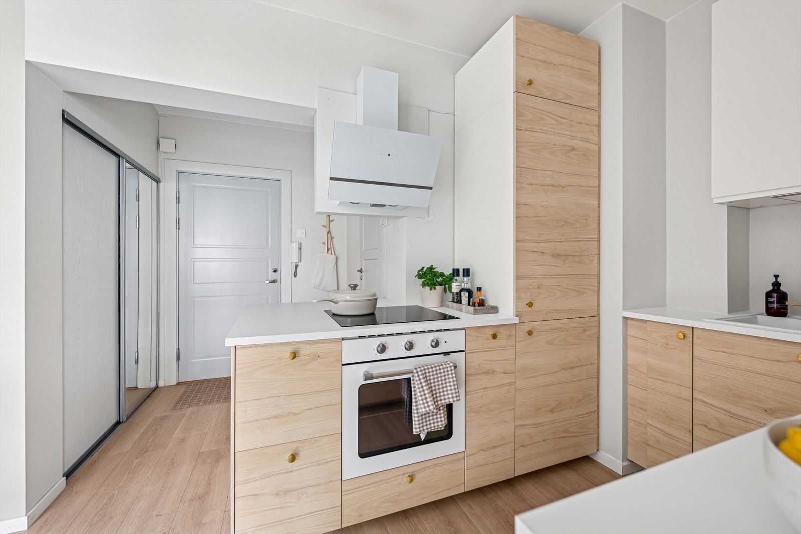 Den hvite benkeplaten og eikefrontene gir kjøkkenet et lyst og innbydende preg, samtidig som de er enkle å holde rene og vedlikeholde. Galleribilde