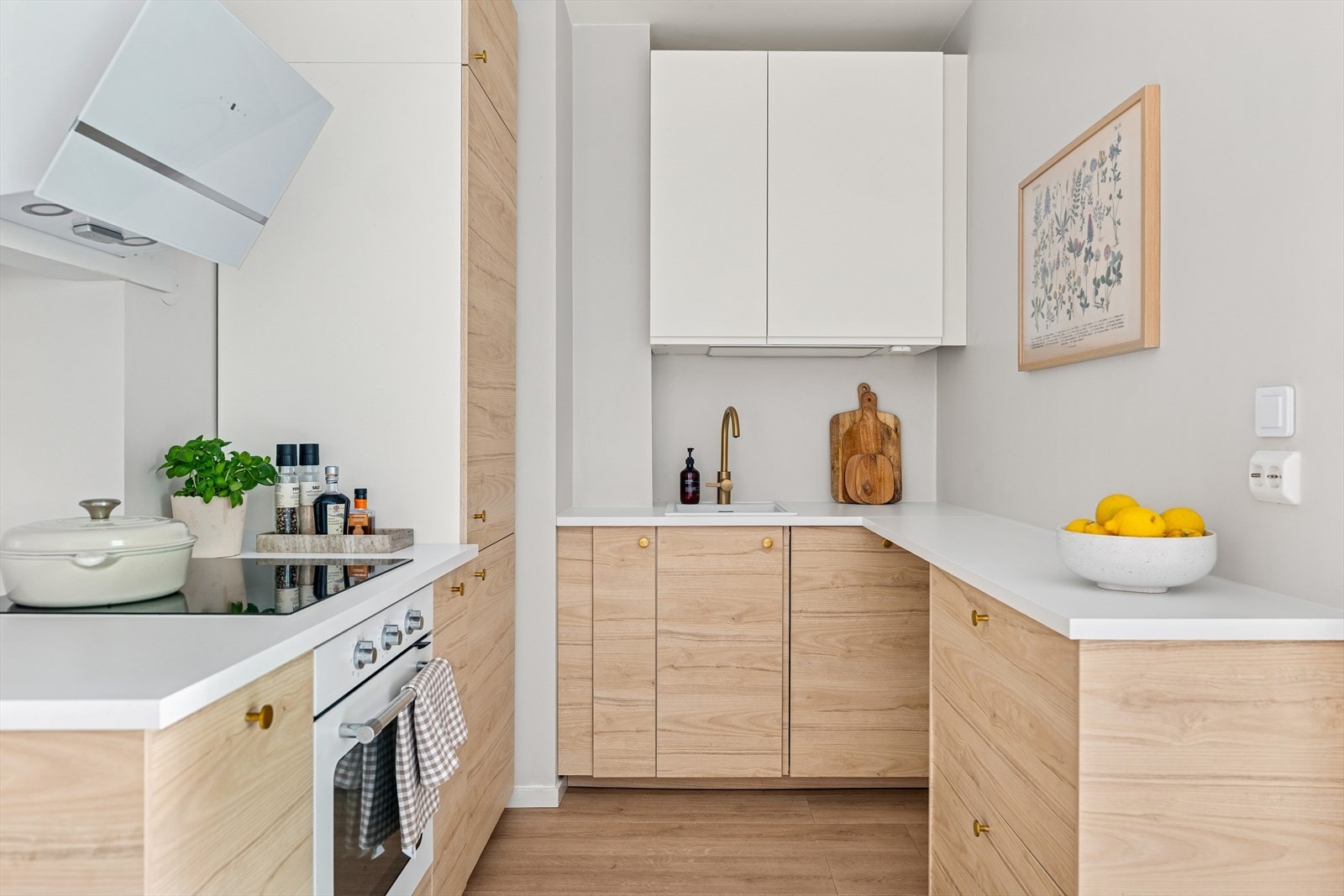 Kjøkkenet ble oppgradert i 2022 og har hvite benkeplater og fronter med eikfarge, som gir et stilrent og tidløst uttrykk. Galleribilde