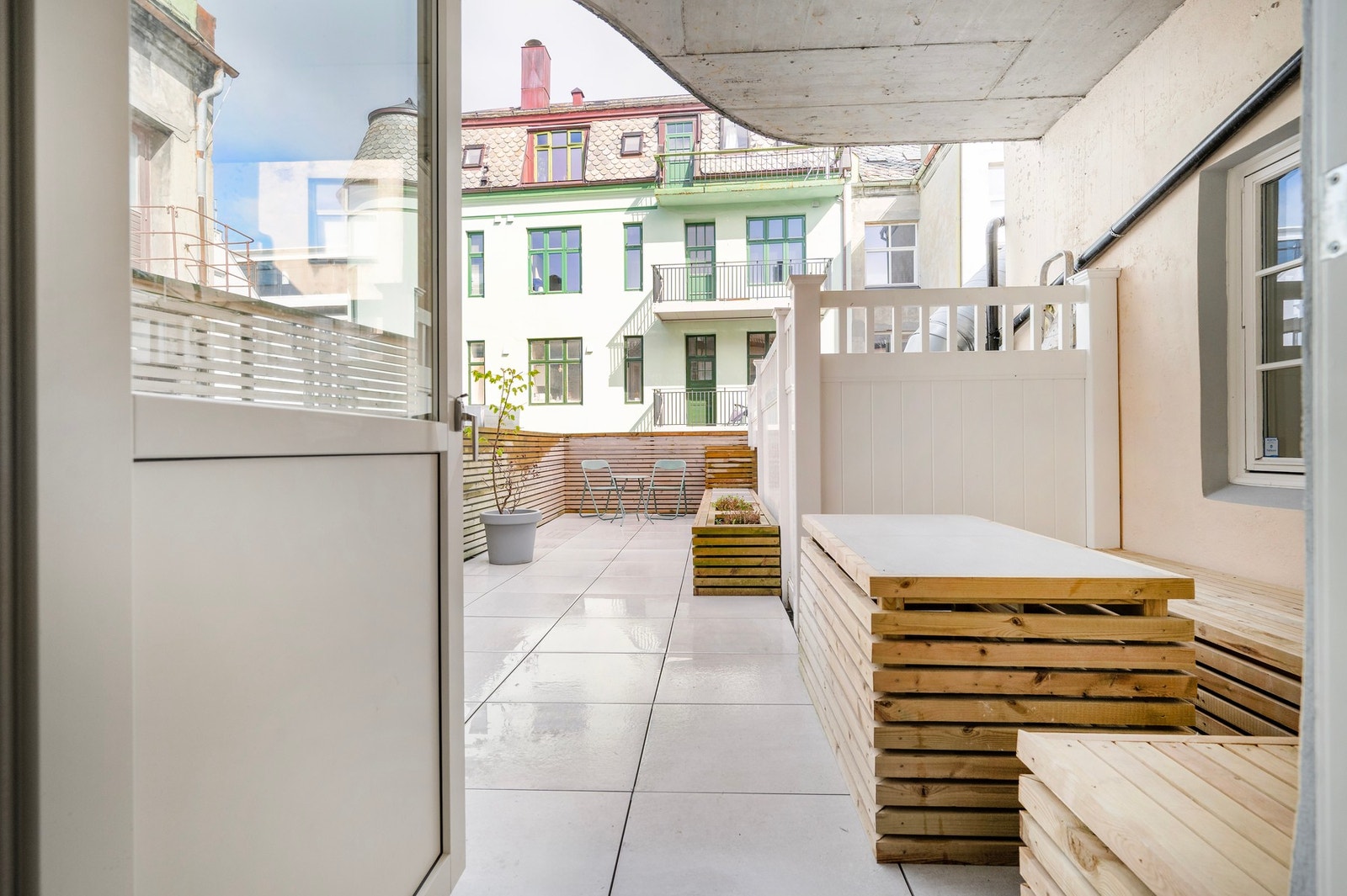 Terrassen er oppbygget av flisbelagt betongdekke og rekkverk i tre og plast. Galleribilde