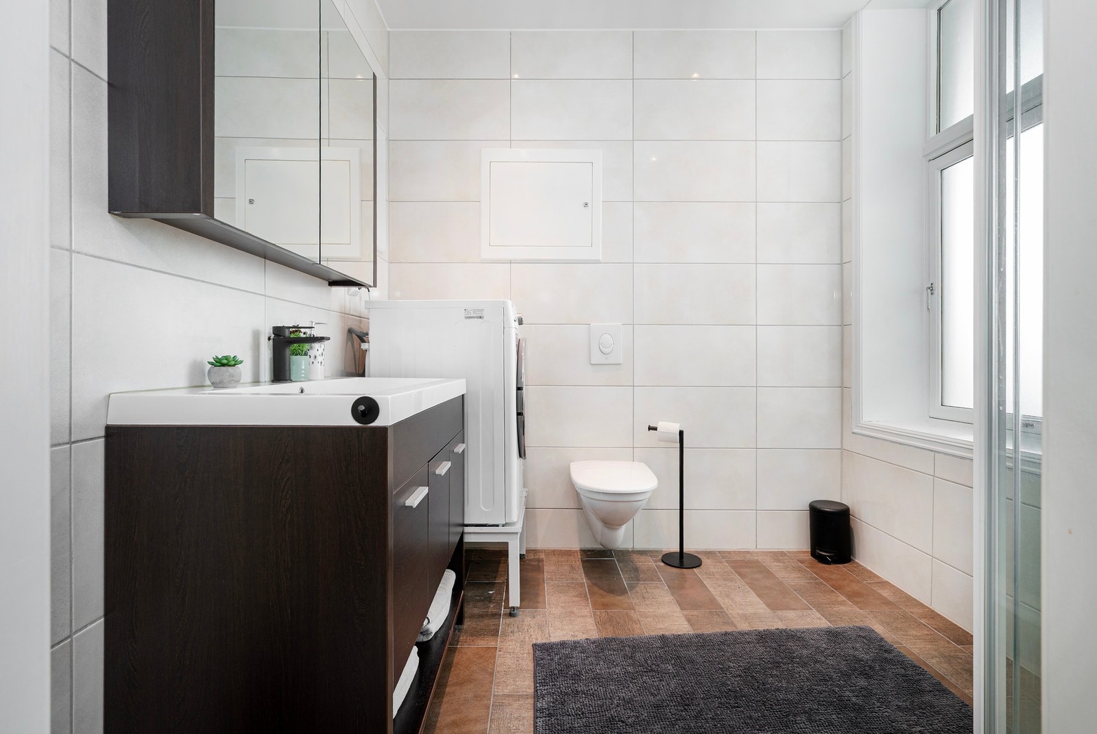 Badet har innredning med nedfelt servant og veggmontert toalett. Galleribilde