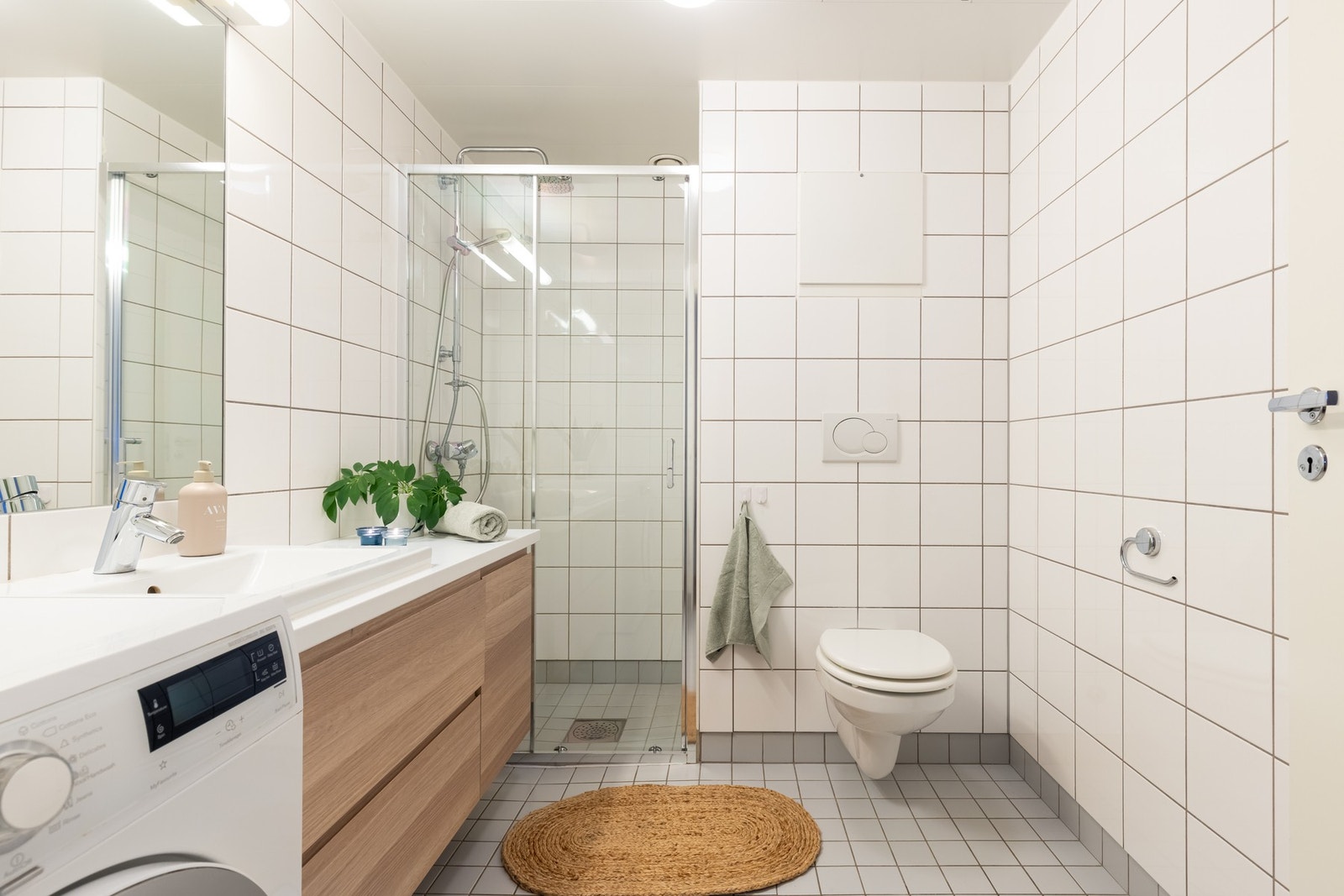 Leiligheten har et lyst, flislagt baderom med varme i gulv. Galleribilde