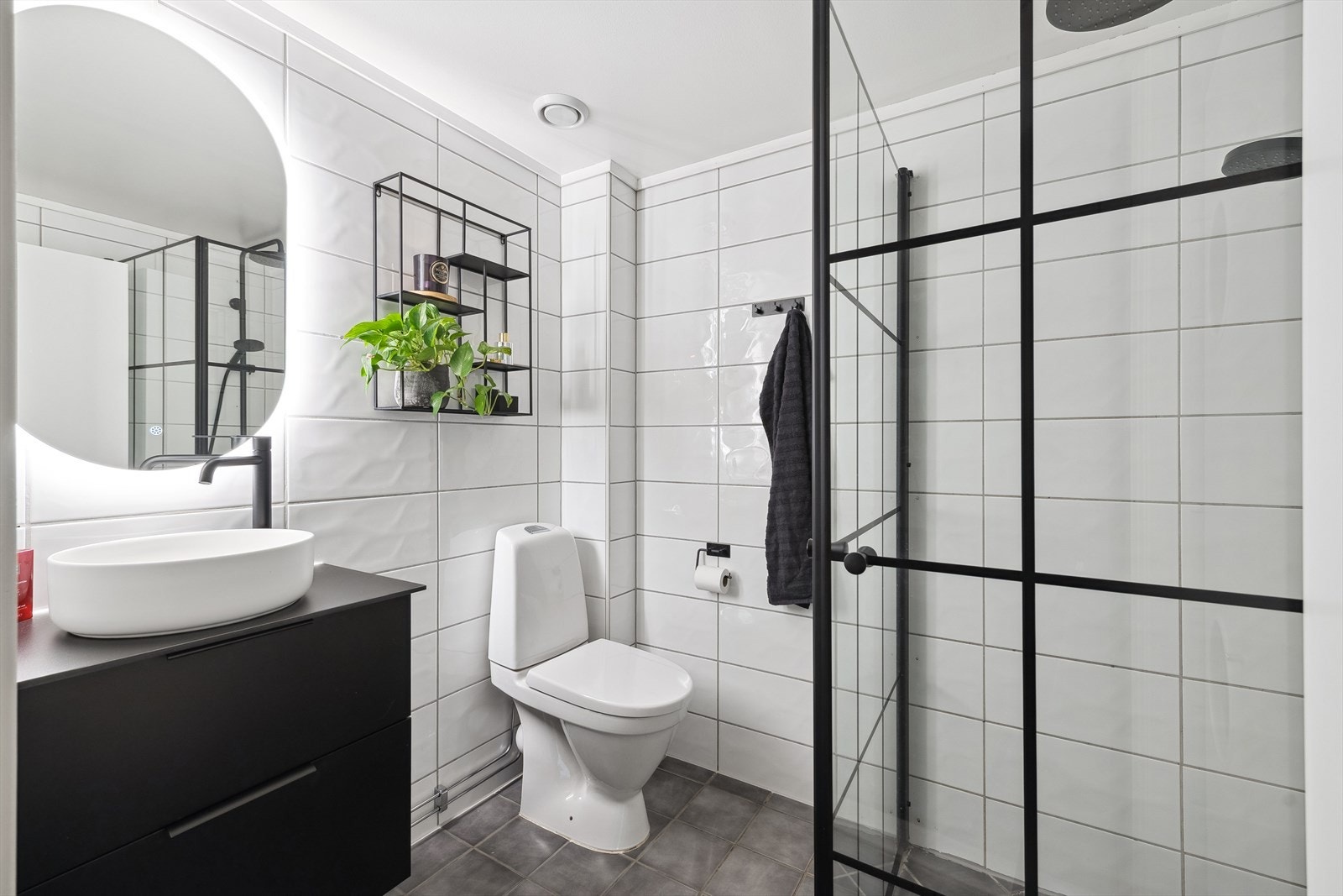 Lekkert bad med dusjhjørne, baderomsinnredning med speilskap og varmekabler i gulv Galleribilde