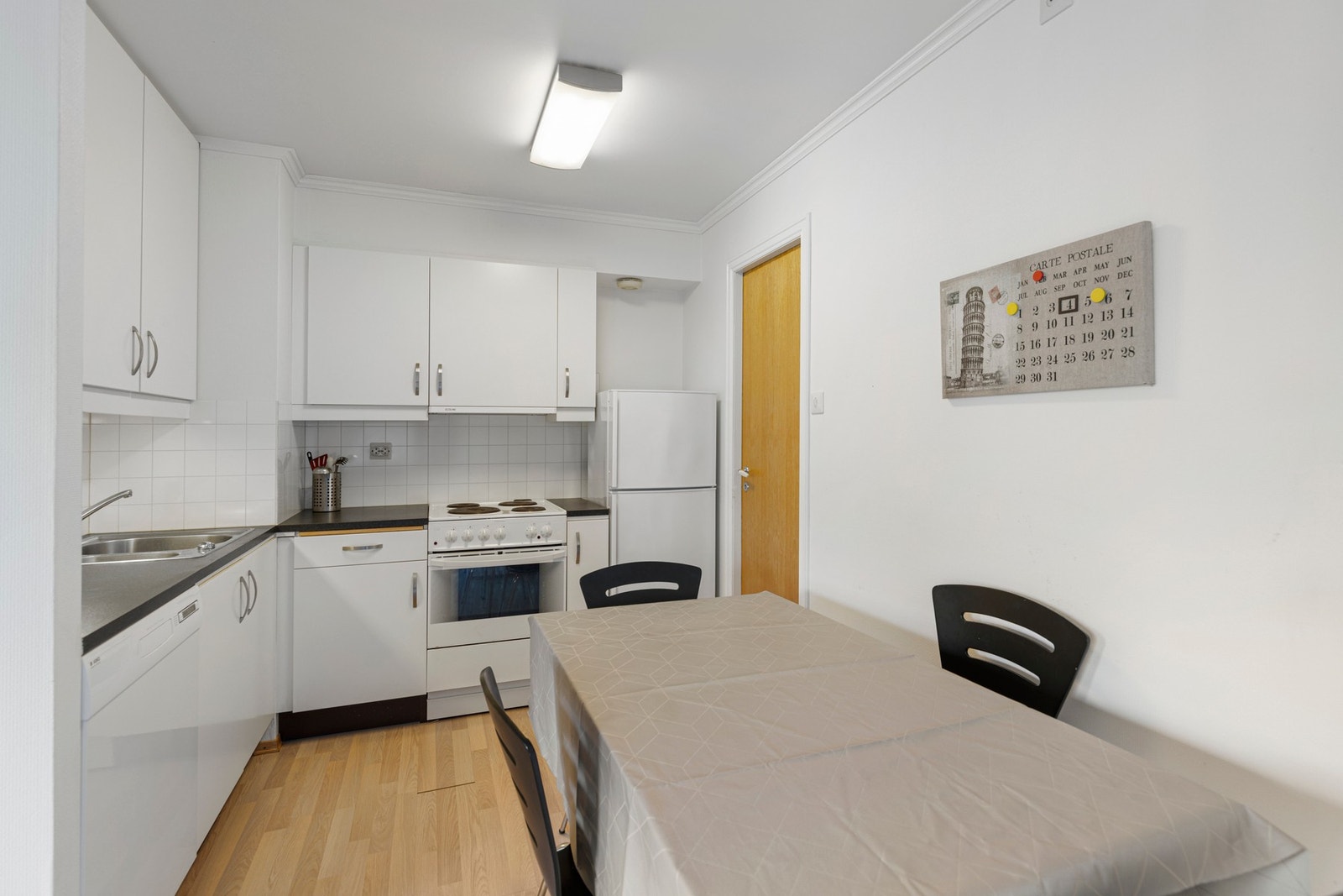 Kjøkkenet har innredning i hvite, slette fronter, laminat benkeplate med plater mot overskap, ventilator, utslagsvask, oppvaskkum og opplegg for oppvaskmaskin. Galleribilde