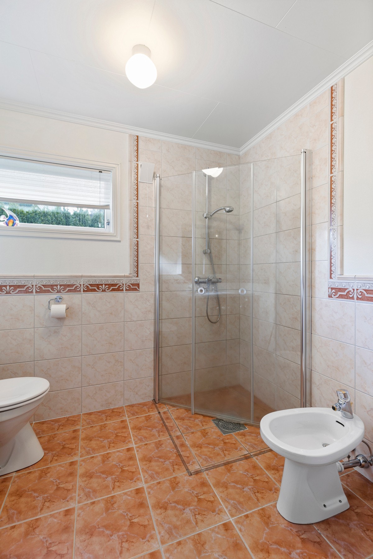 Badet i hovedetasjen er fra byggeår med flislagte gulv og vegger. Galleribilde