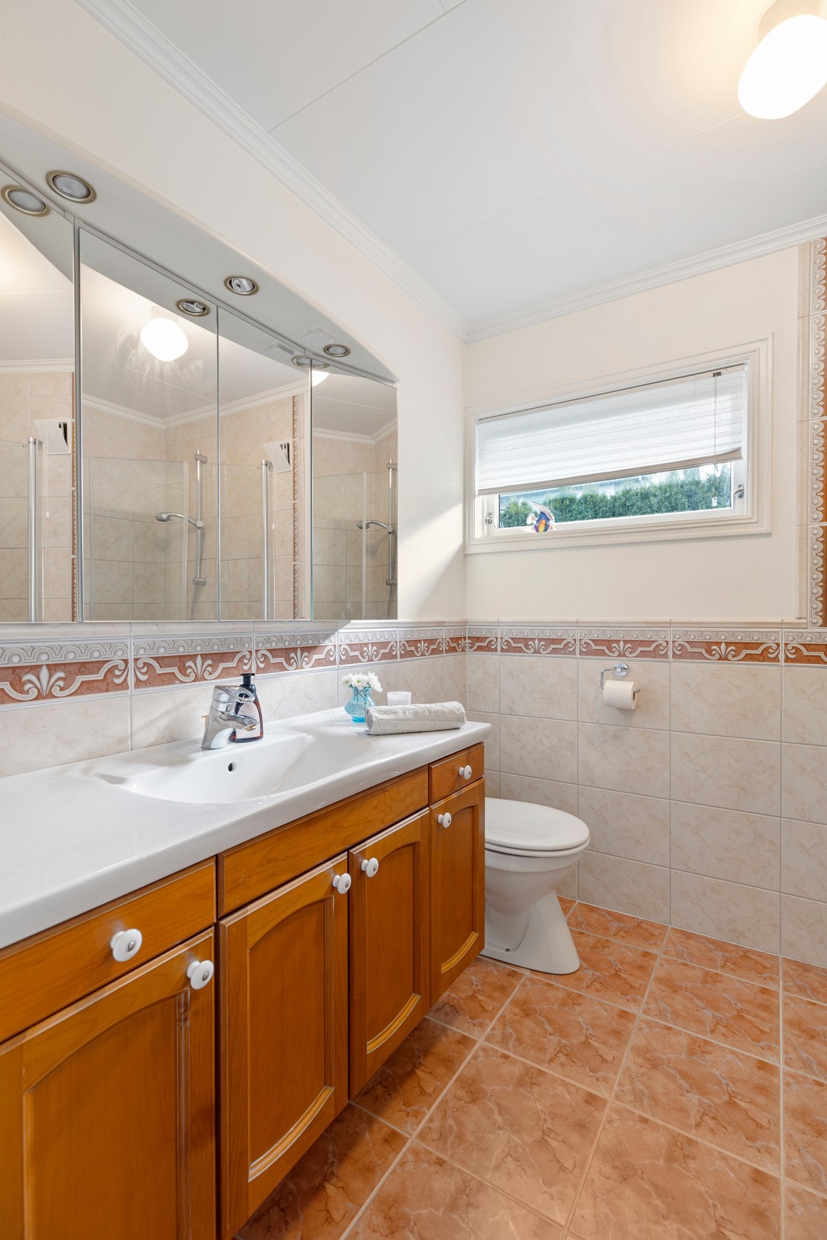 Rommet inneholder videre varmekabler i gulv, dusj med innfellbare dusjvegger, toalett, bidet og baderomsinnredning med heldekkende servant. Galleribilde