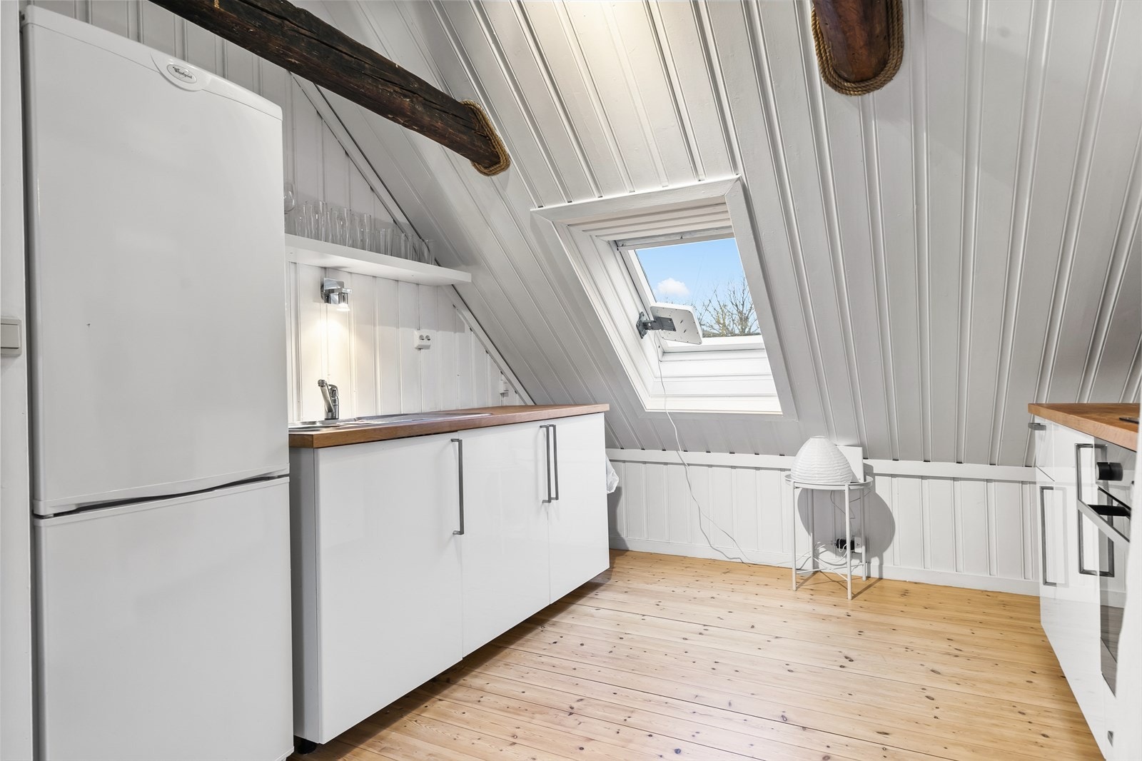 Kjøkkenet består av glanset over-/underskap og heltre benkeplate Galleribilde