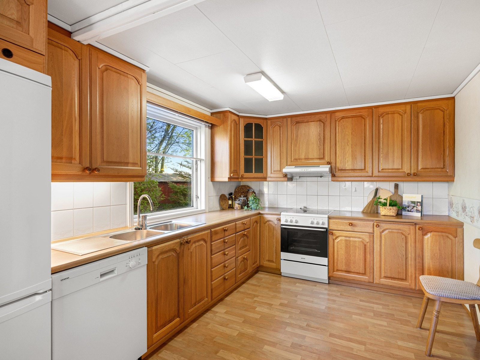 Romslig kjøkkeninnredning med god skap og benkeplass. Galleribilde