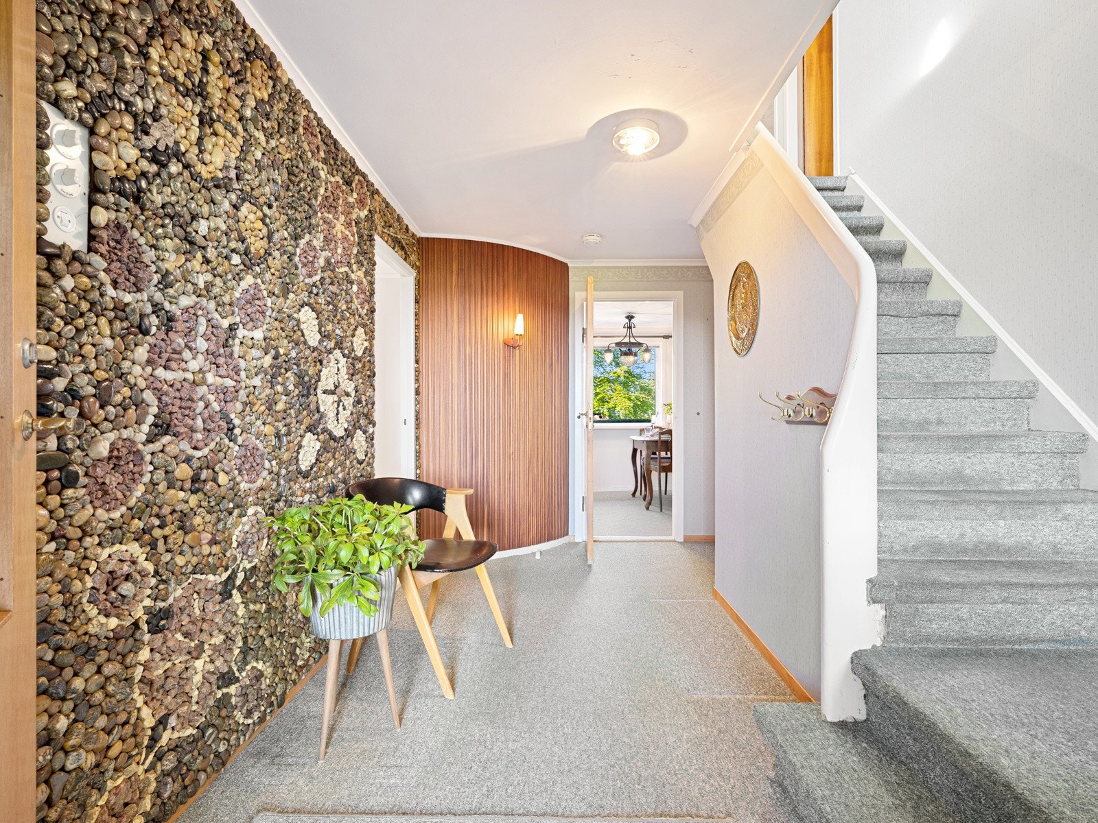 Lekre detaljer i inngangspartiet med vegg som har dekor av flotte steiner, som er gjort av selger selv. Legg også merke til veggen som går i bue i teak material. Galleribilde