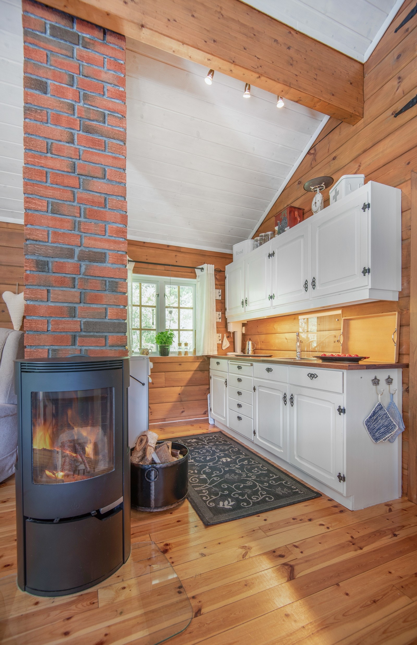 Kjøkkeninnredningen har hvite, malte profilerte fronter og det er laminat benkeplate. Nedfelt oppvaskkum med splashboard bak. Galleribilde