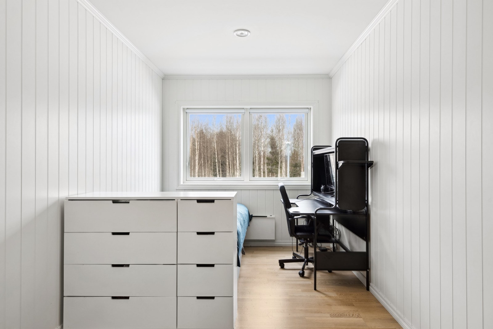 Det andre soverommet er noe mindre, men fortsatt romslig. Her er det panelovn montert på vegg som varmekilde, og garderobeskap etablert rett innenfor døren. Galleribilde