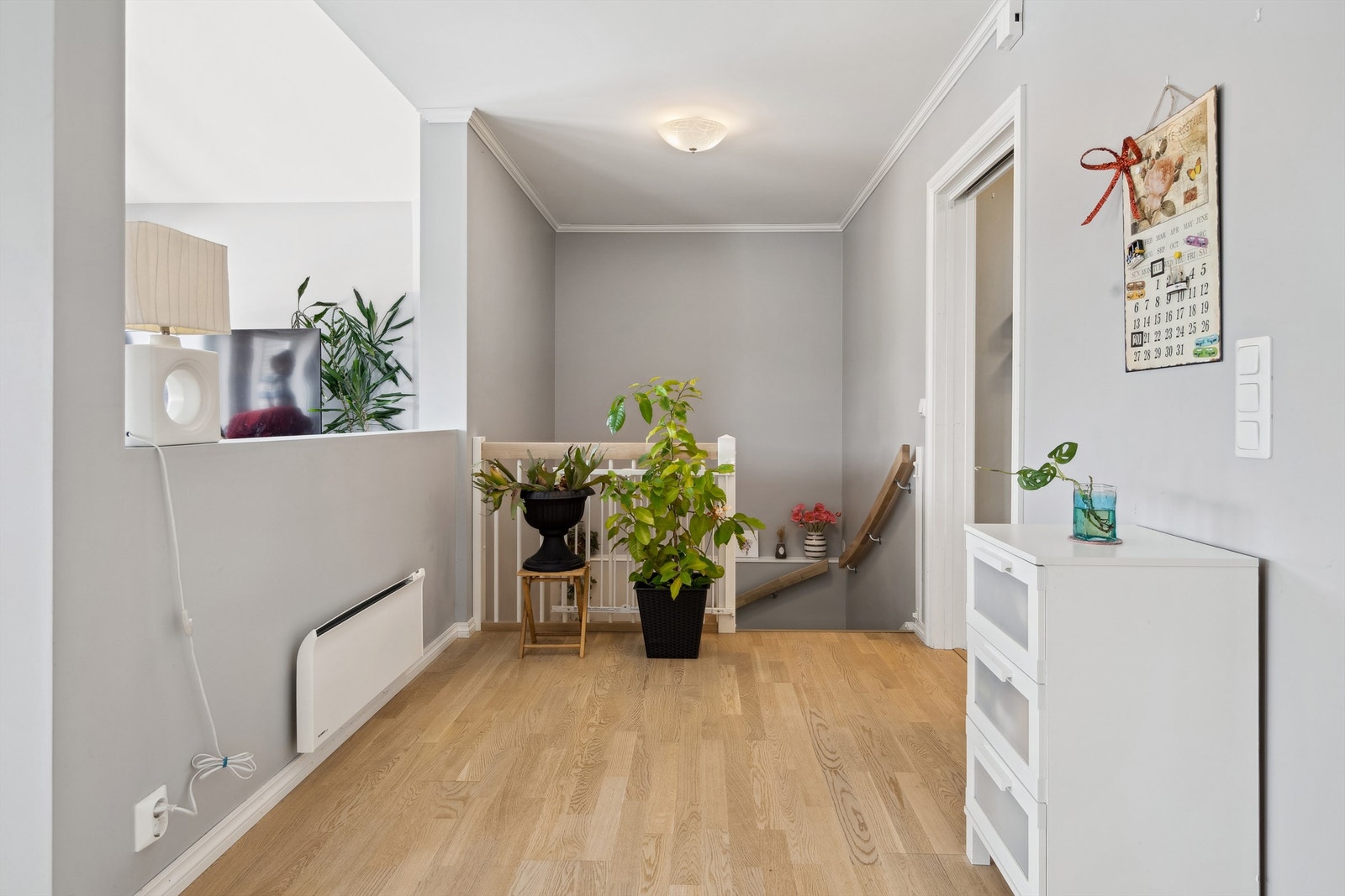 Videre inn kommer du inn i en mellomgang. Her er det trapp ned til sokkeletasjen på høyre side og åpen løsning inn til resten av boligen. Det er delevegg inn til stue fra mellomgangen. Entréen og mellomgangen har panelovner montert på veggene. Galleribilde