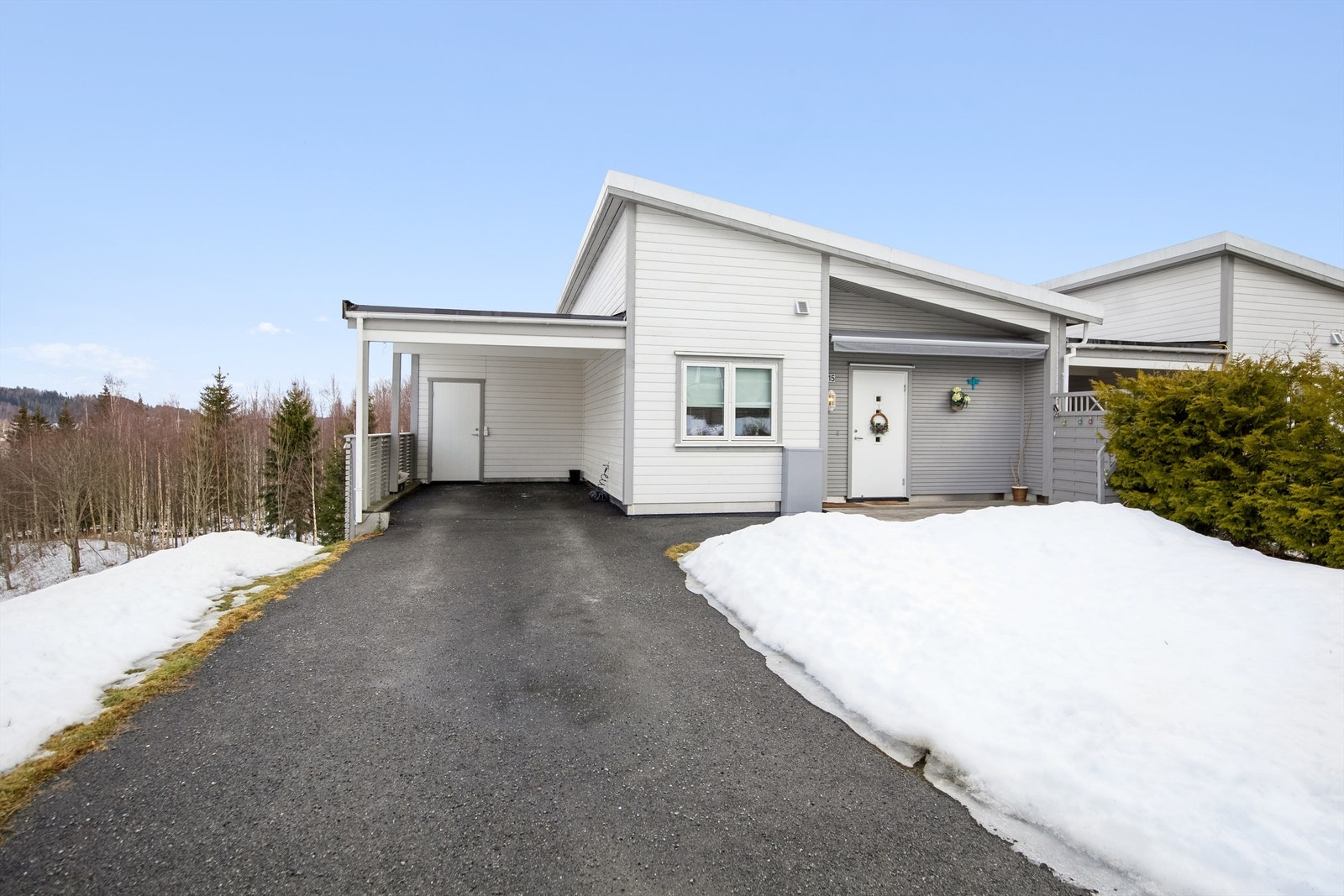 Gruset innkjøring og carport. Andelen har ansvar for hageflekken utenfor inngangspartiet. Galleribilde