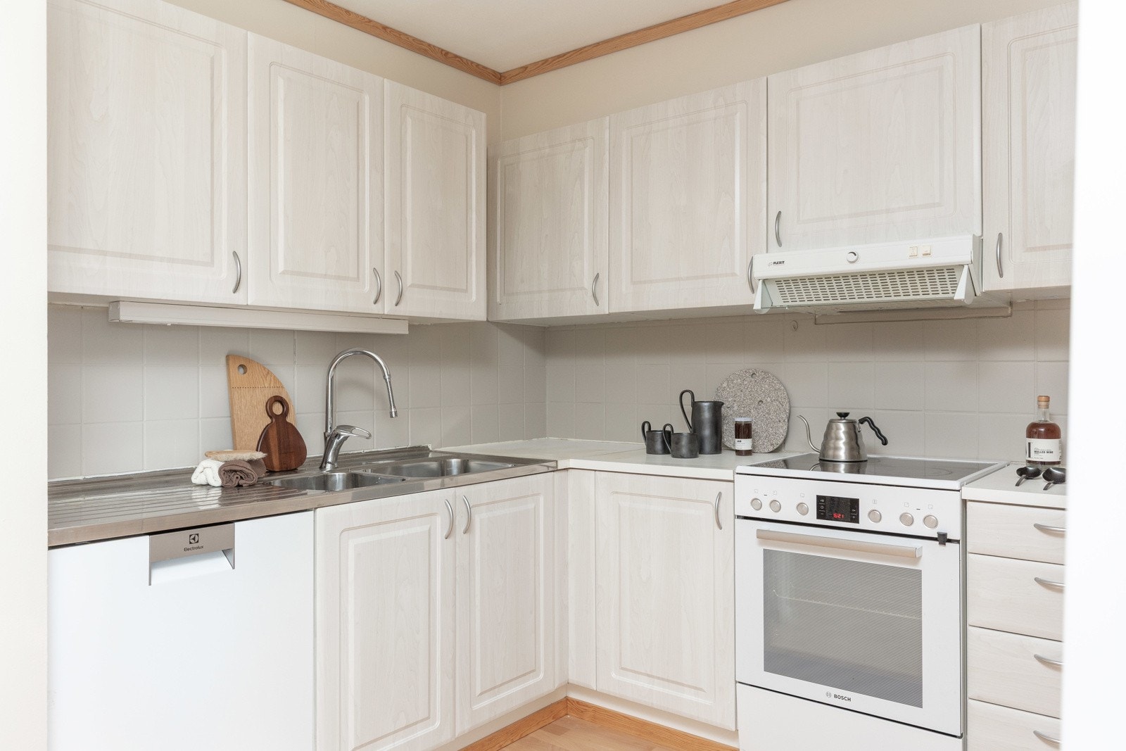 Fliser, lyssetting og effektive løsninger gir en funksjonell og trivelig kjøkkenopplevelse. Galleribilde