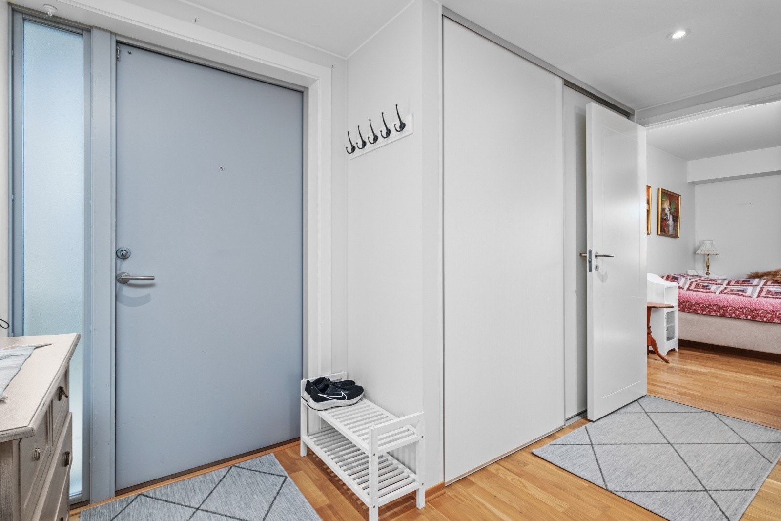 Fin entre med plass til kommode og skoskap. Skyvedørsgarderobe for oppbevaring av klær. Galleribilde