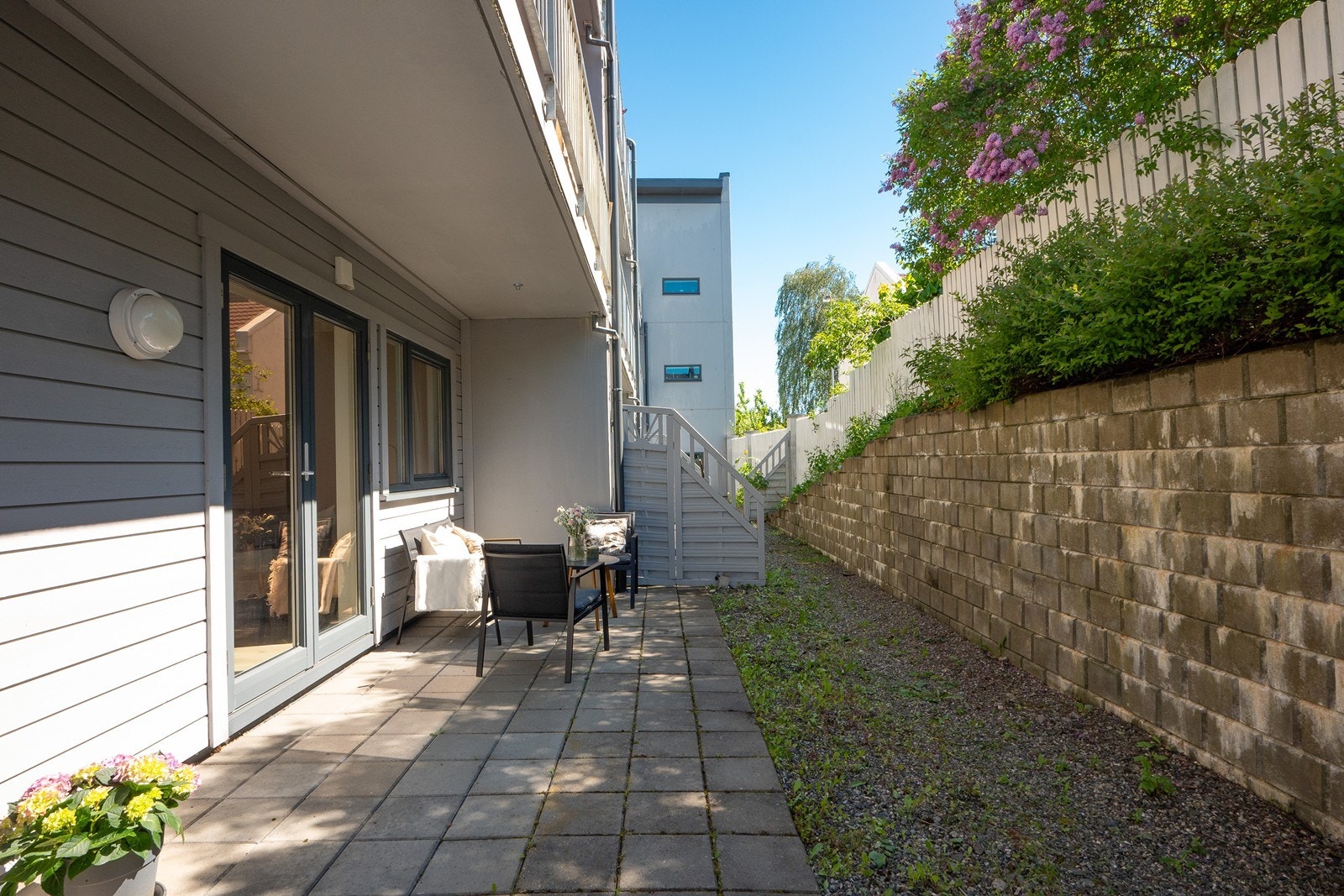 Terrassen er belagt med steinheller og har god plass til beplantning, sittegruppe eller spisebord. Galleribilde
