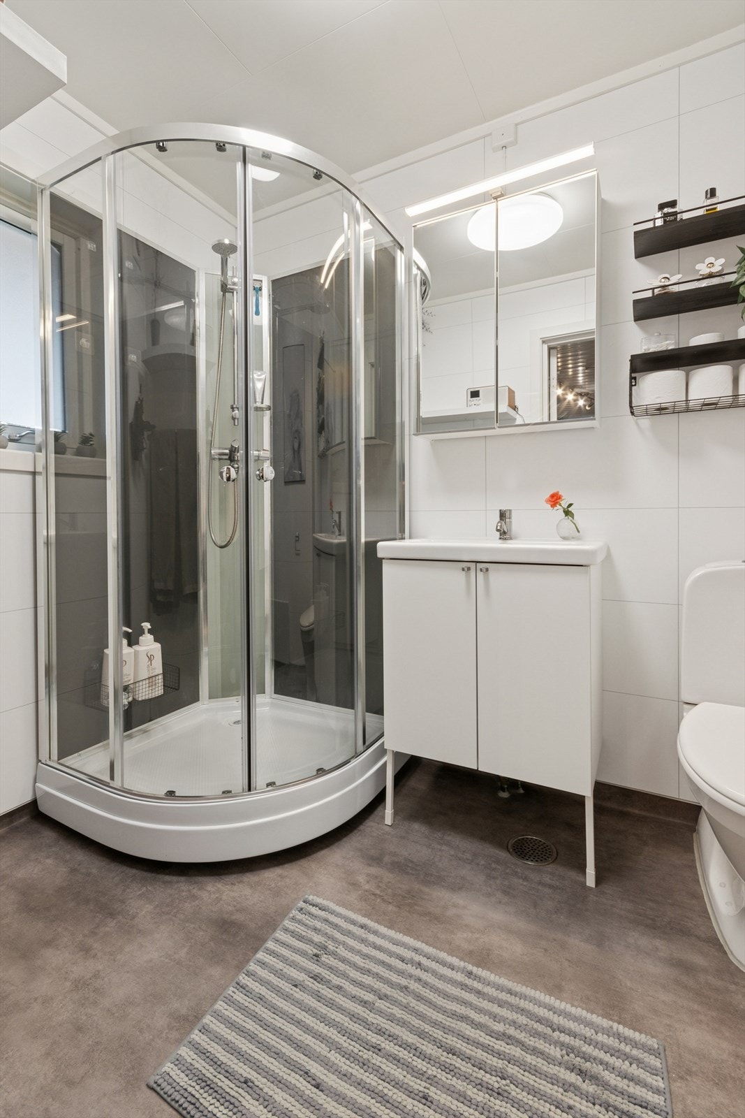 Badet i første etasje er fra 2023. Utstyrt med dusjkabinett, gulvstående wc og lys baderomsinnredning. Galleribilde