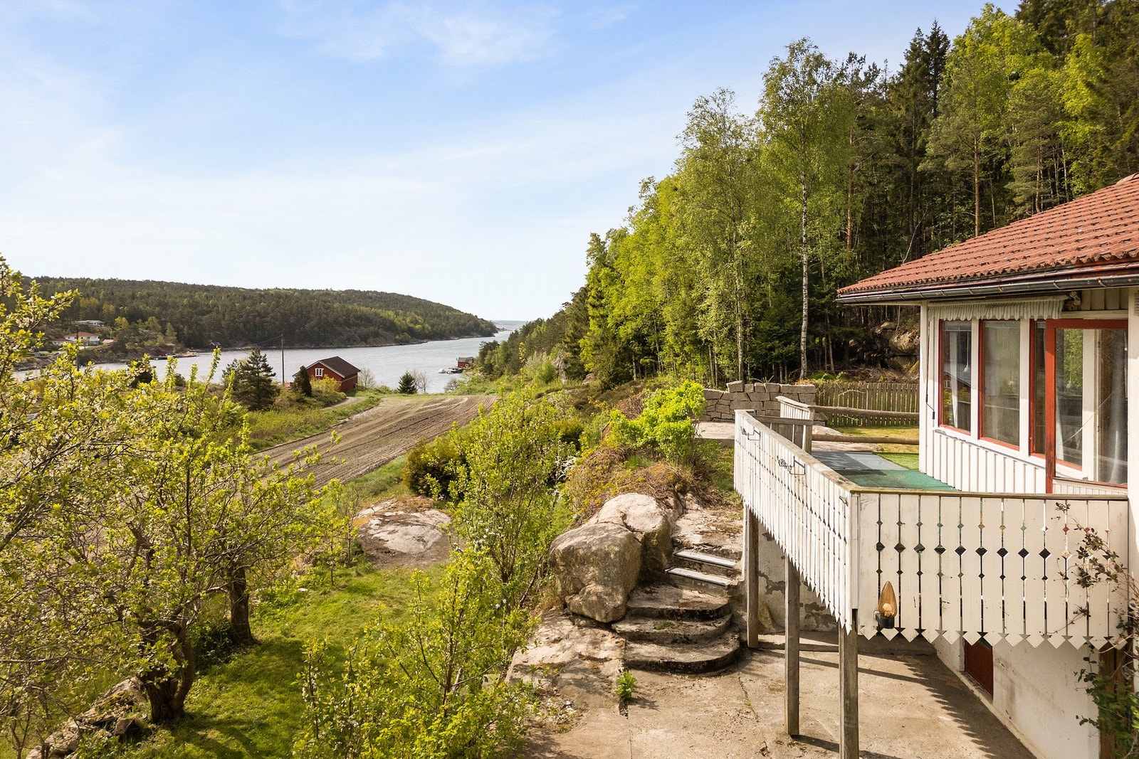 Stor terrasse på to sider av huset - Totalt ca. 36 m² med utsikt mot sjø i grønne omgivelser. Galleribilde