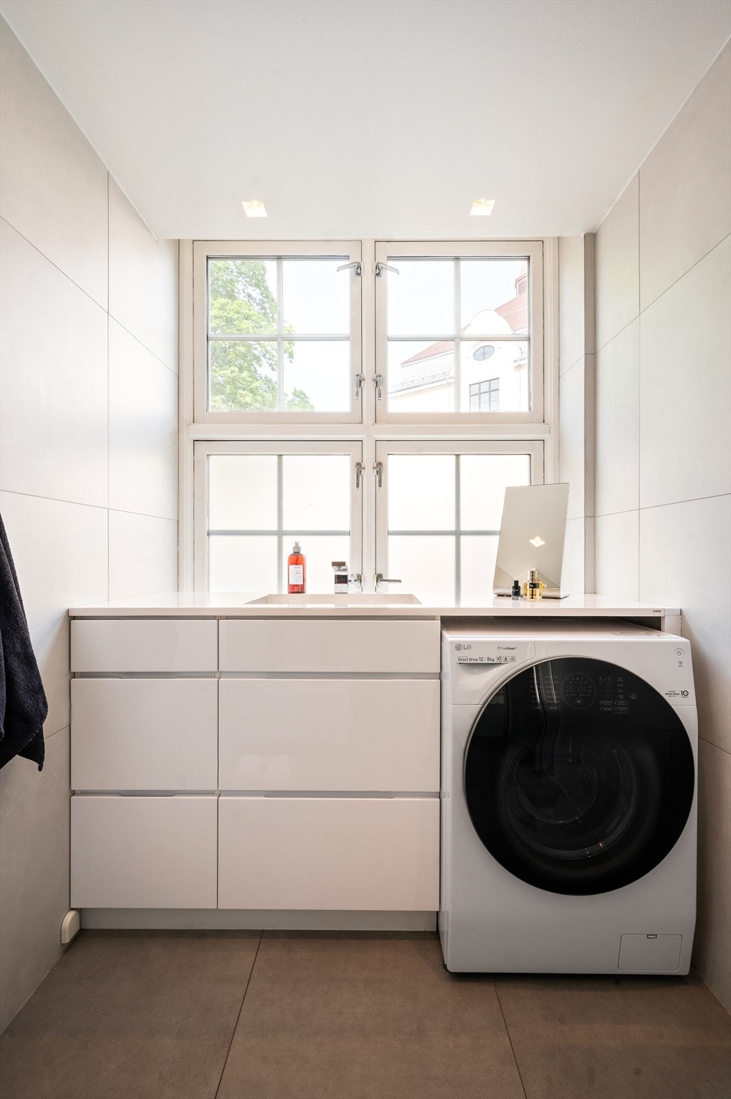 God oppbevaringsplass til baderomsartikler i skuffeseksjoner og plass til vaskemaskin under benkeplate. Galleribilde