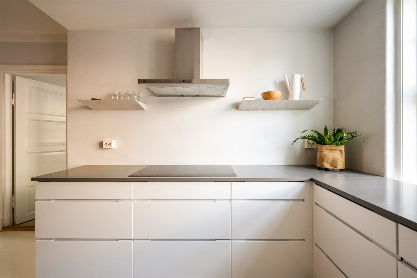 Kjøkkeninnredning med glatte fronter og benkeplate i stein fra Jetstone med nedfelt vaskekum. Galleribilde