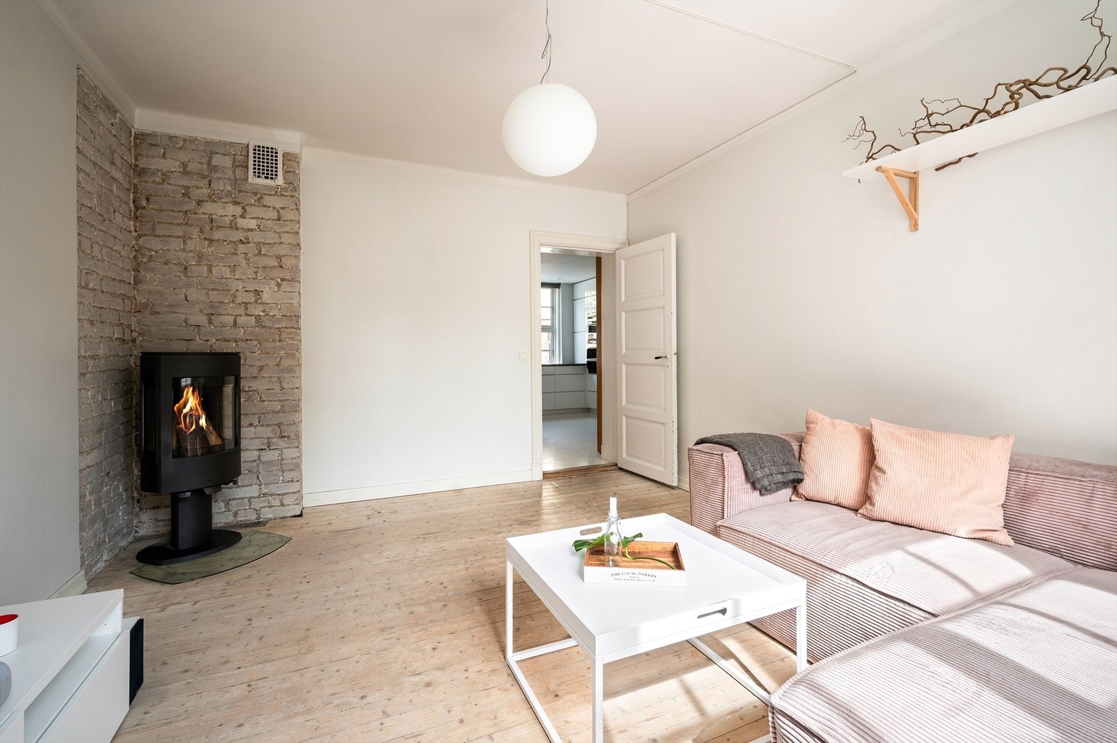 Lys og trivelig stue med sjarmerende tregulv og moderne peisovn plassert i hjørnet. Galleribilde