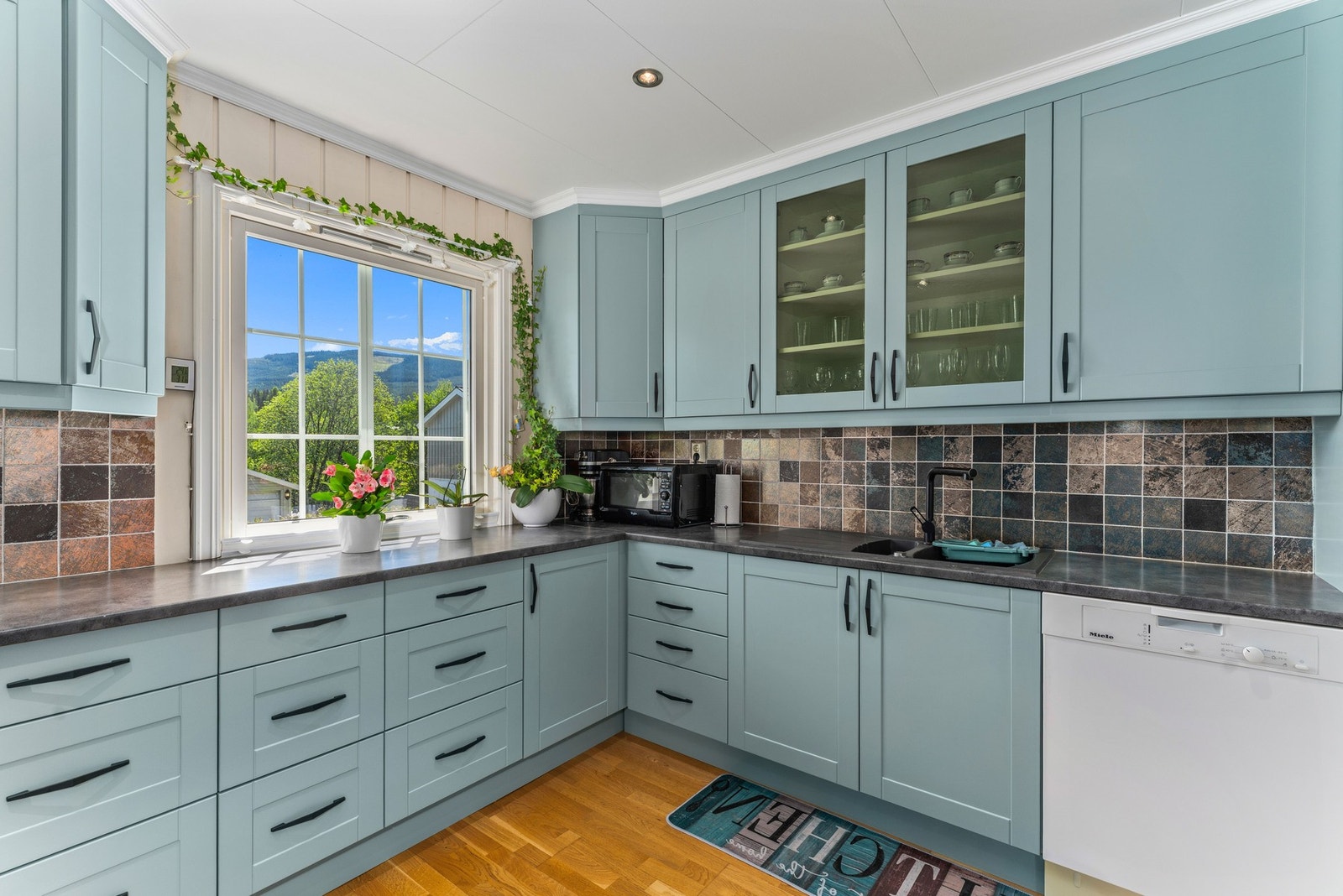 Benkeplaten er i slitesterk laminat, og kjøkkenvasken har to kummer med avrenningsfelt. Galleribilde