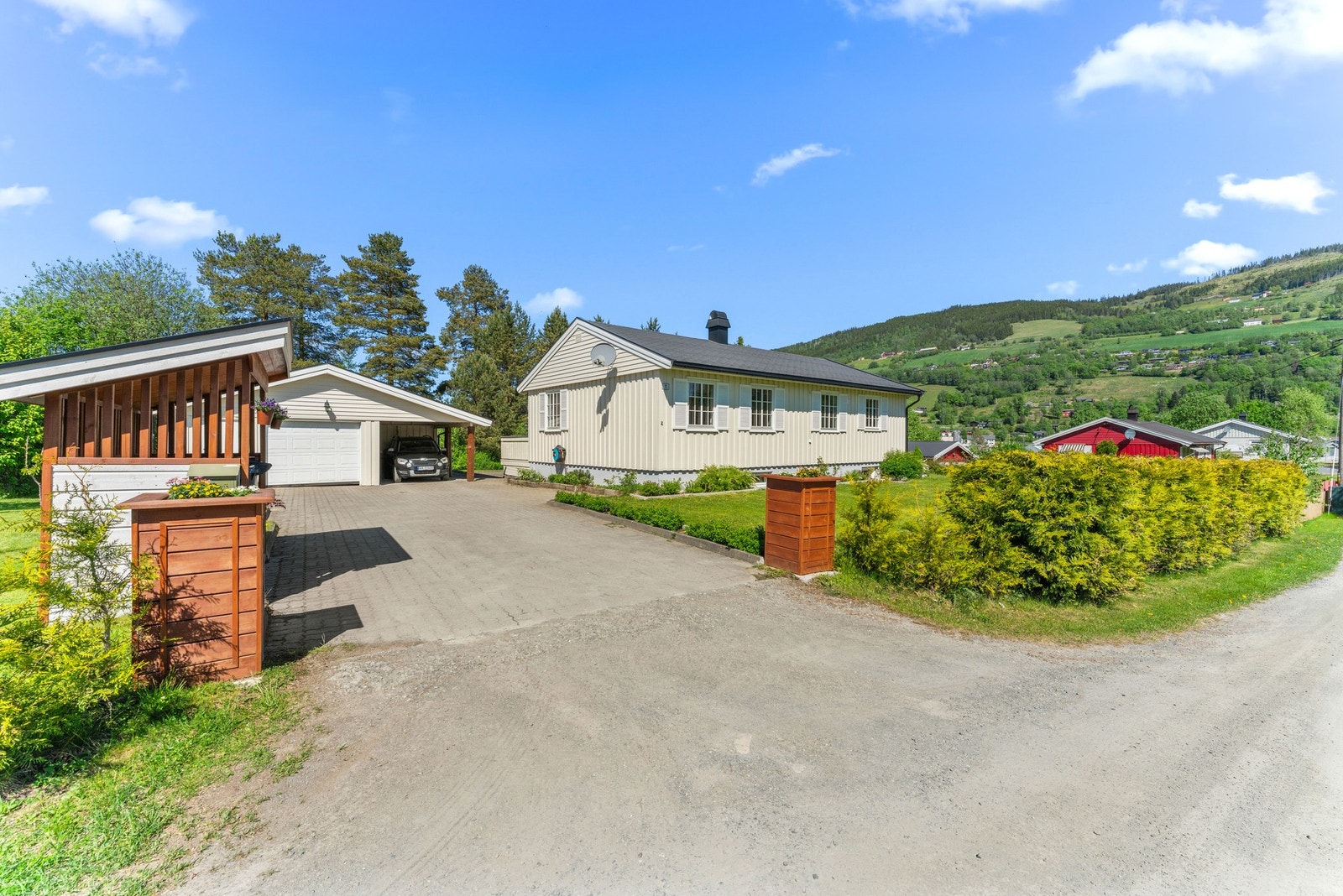 Eiendommen er svært pent opparbeidet, med steinbelagt gårdsplass, grønne plener, hekk og blomsterbed. Galleribilde