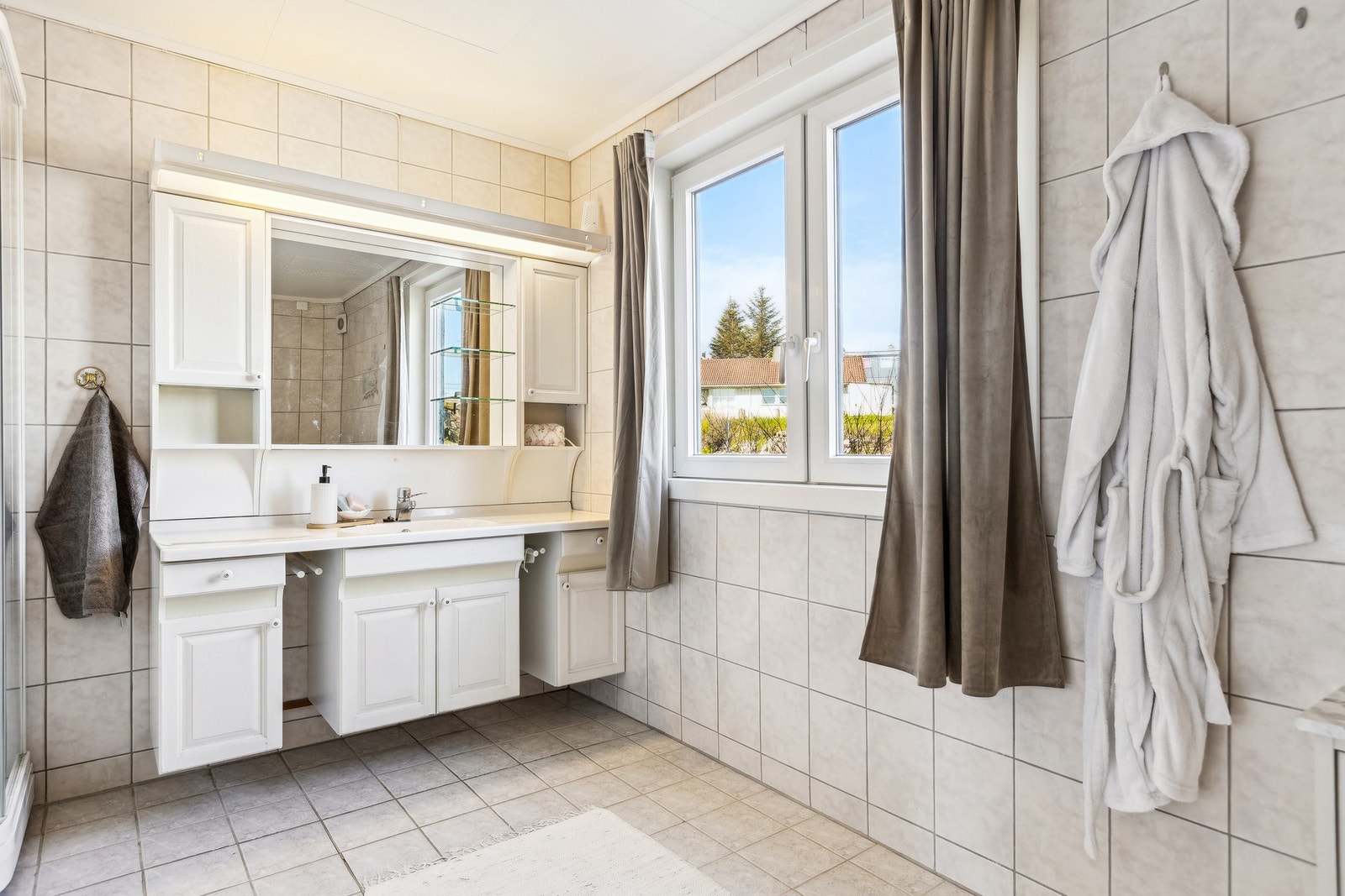 Romslig baderom på 9 kvm med smarte oppbevaringsløsninger og god plass til det du trenger i hverdagen. Galleribilde