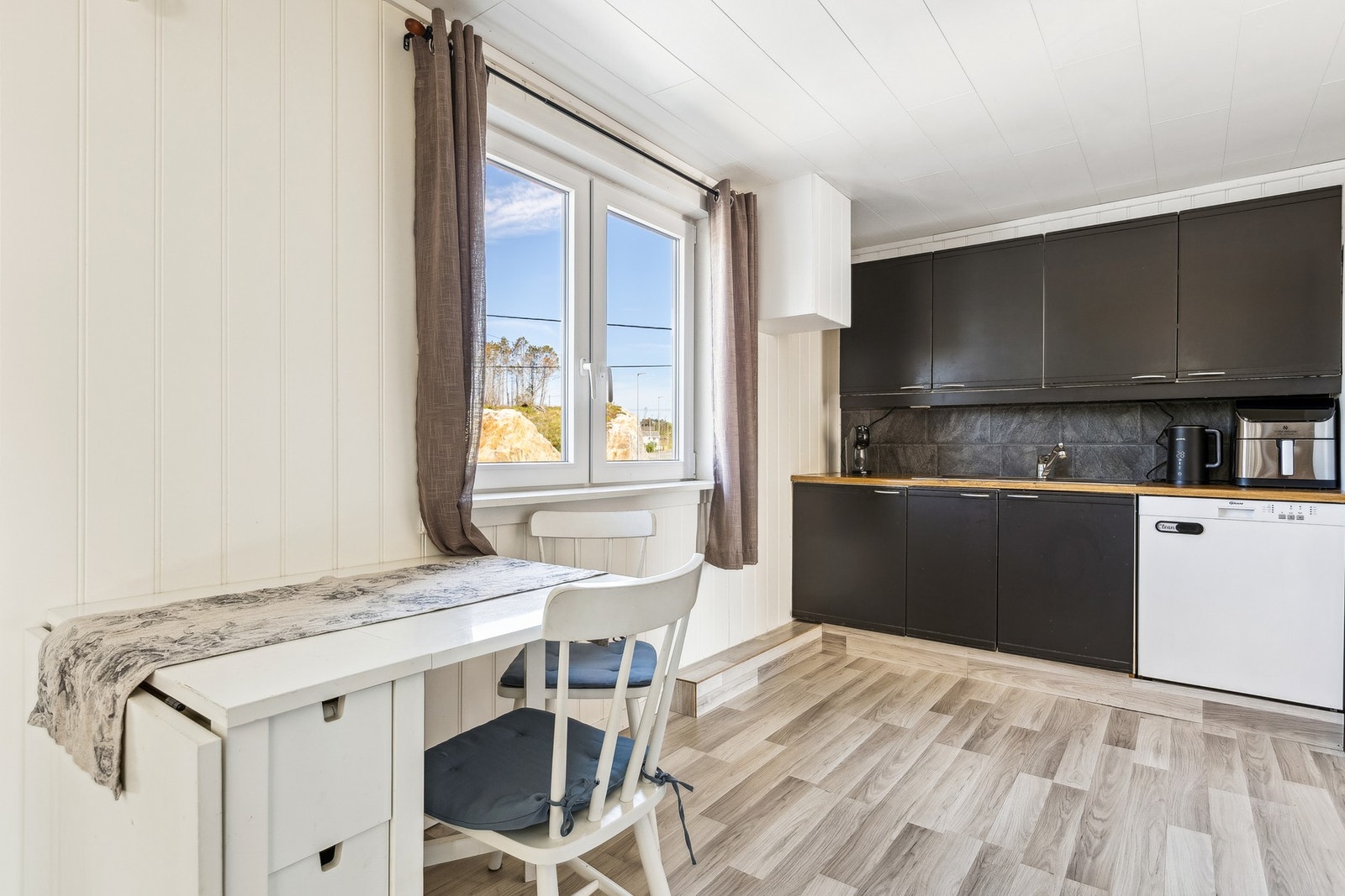 Funksjonelt kjøkken med åpen løsning og plass til spisegruppe. Galleribilde