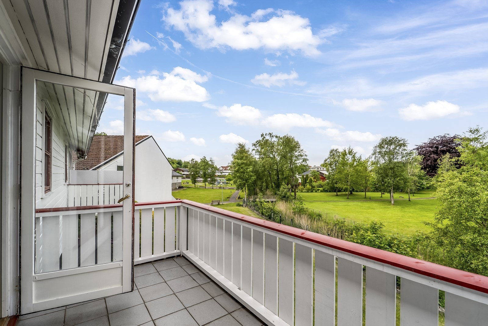 Utgang til en solrik balkong fra stue. Fin utsikt mot elva og området rundt. Galleribilde
