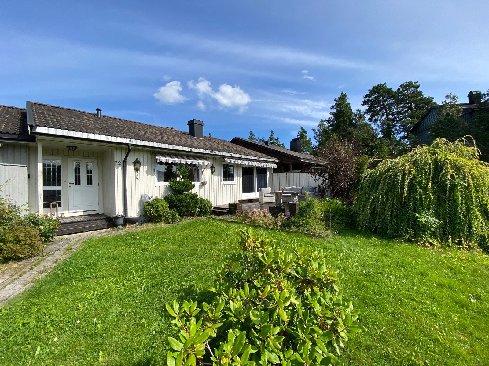 Boligen ligger solrikt til med koselig opparbeidet hage med plen og terrasse Galleribilde