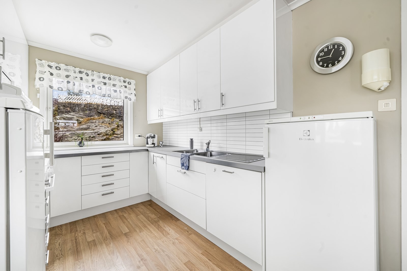 Lys kjøkkeninnredning med godt med skapplass. Galleribilde