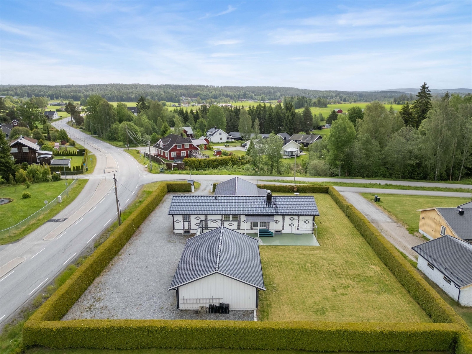 Stor eiendom med hekk som gjerder inn hele eiendommen. Galleribilde