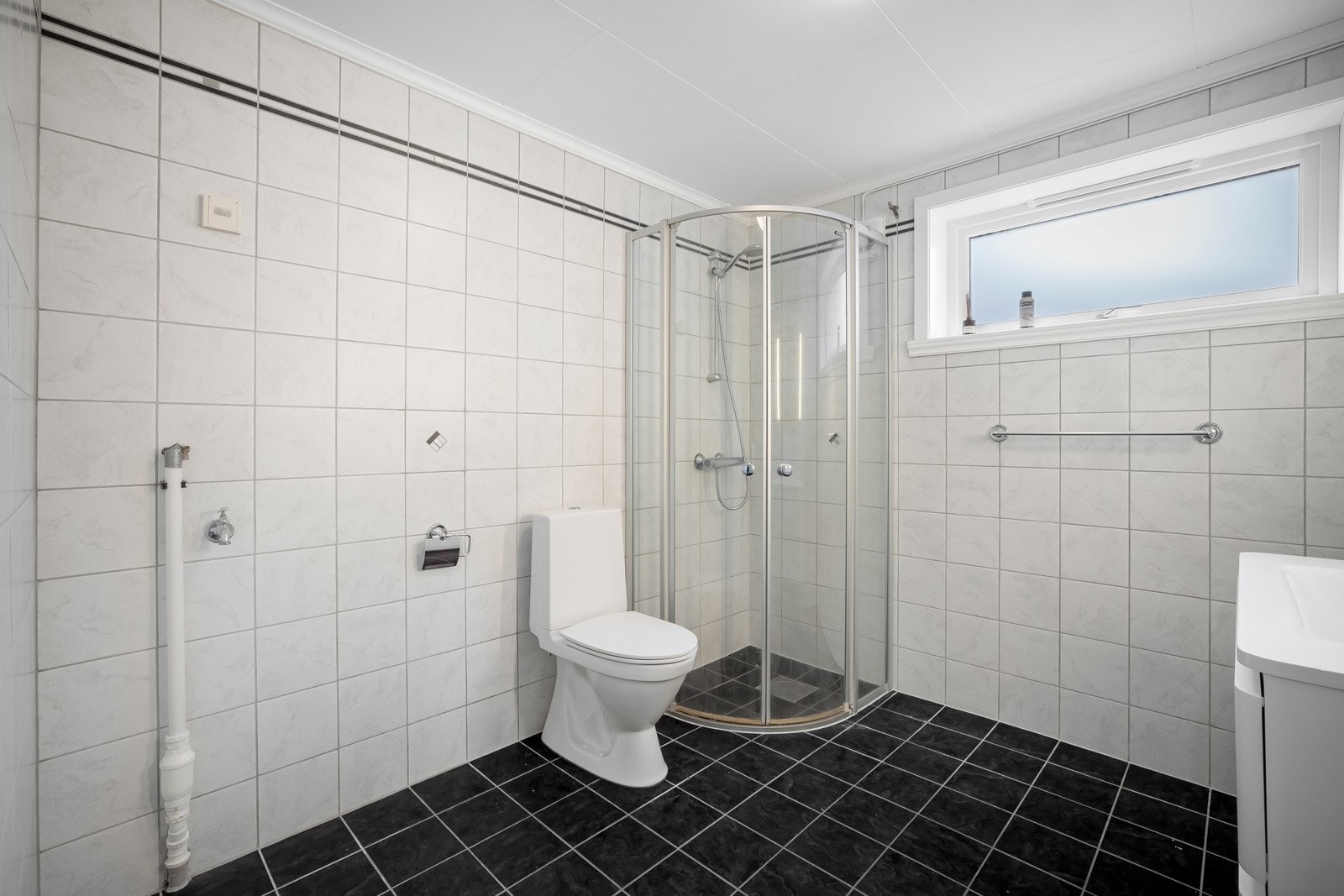 Det er eget dusjhjørne og opplegg for vaskemaskin på badet Galleribilde