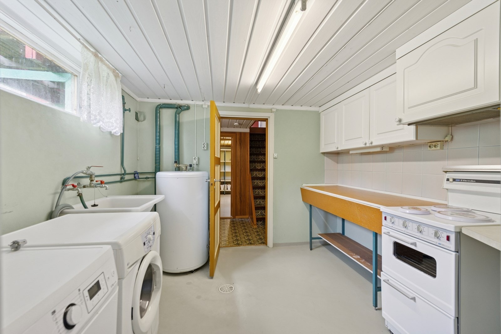 Et av kjellerrommene er i dag innredet med grovkjøkken og har opplegg for vaskemaskin. Galleribilde