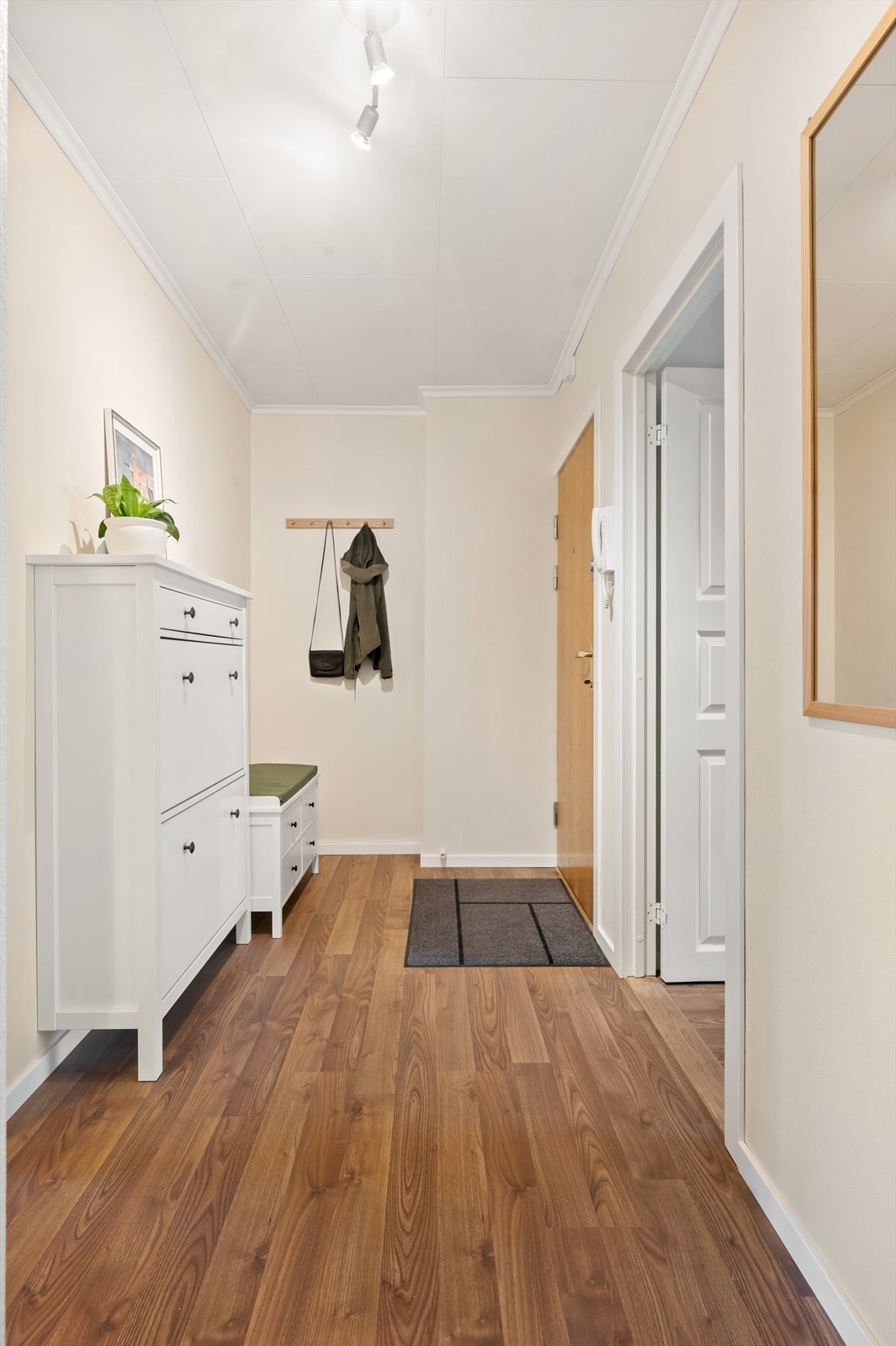 Innbydende entré med plass til kommode, skohylle og oppheng for ytterklær. Galleribilde