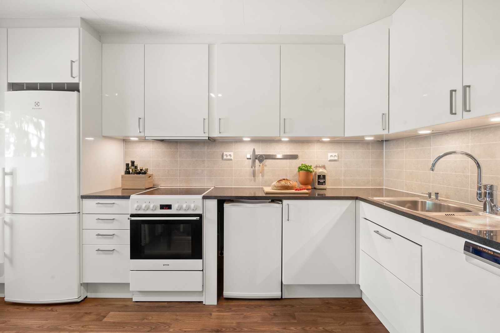 Kjøkkeninnredningen består av glatte fronter, laminert benkeplate og nedsenket oppvaskkum med ett-greps blandebatteri. Galleribilde