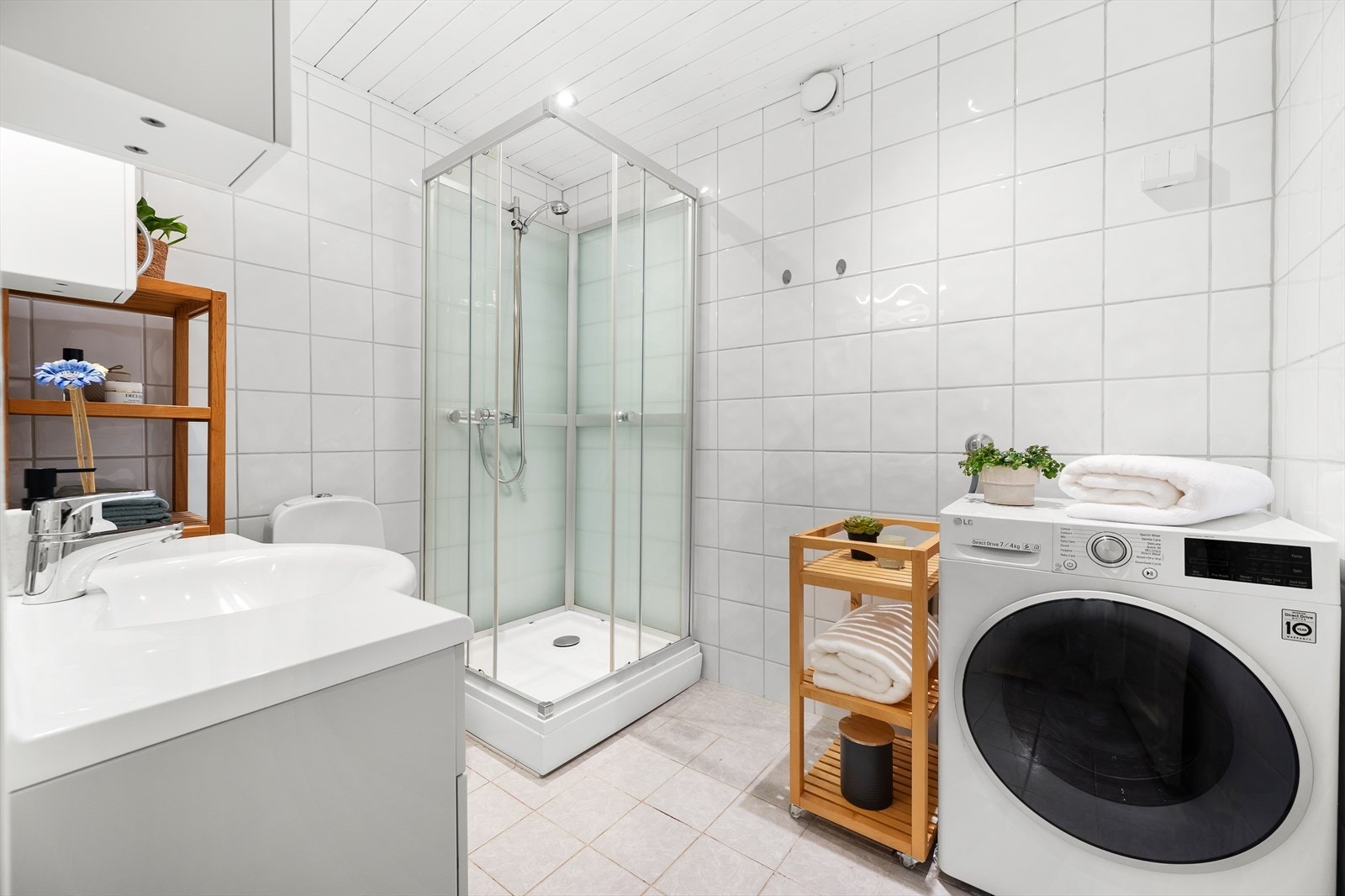 Innredningen består av nedfelt servant med underskap, speil, gulvmontert toalett og dusjkabinett Galleribilde