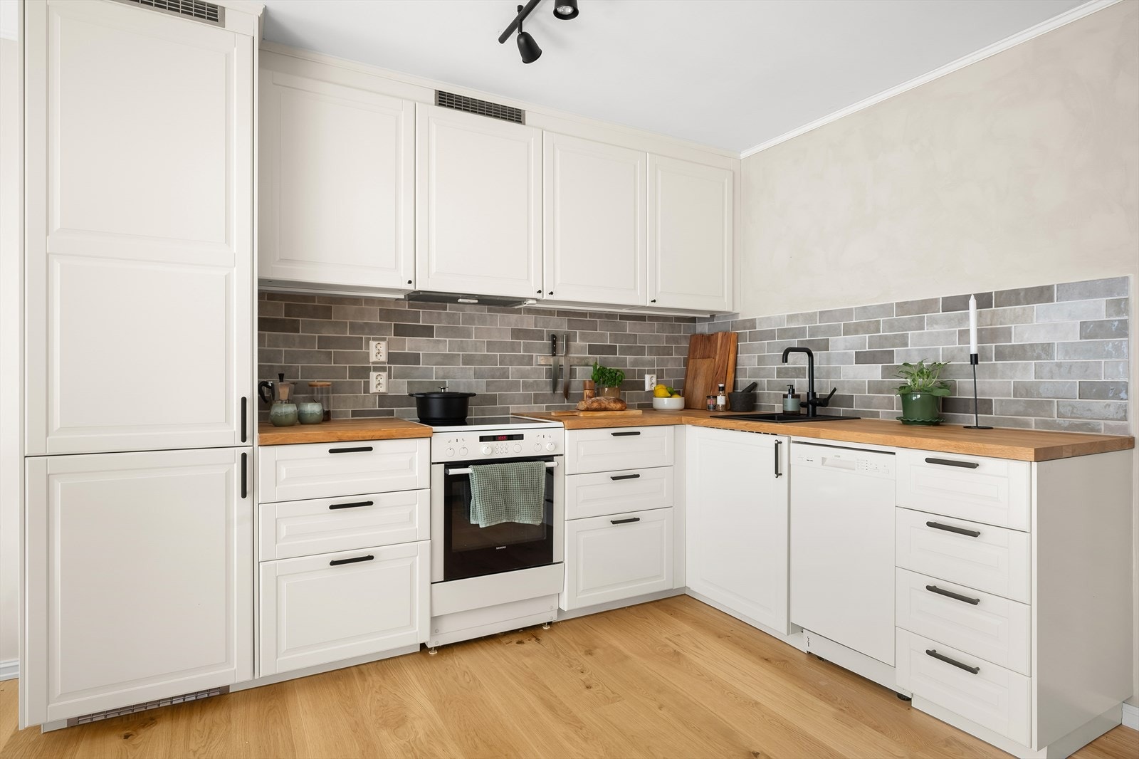 Flott IKEA-kjøkken fra 2024 med integrert kjøl/fryse og det er plass til frittstående komfyr og oppvaskmaskin. Galleribilde